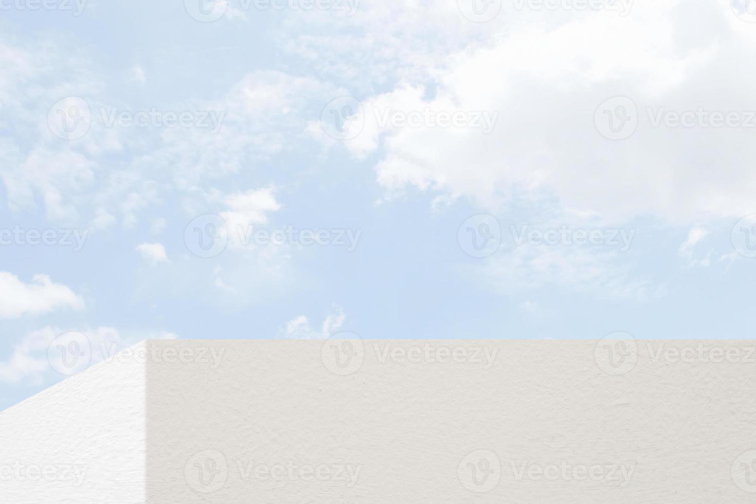 White Concrete Wall at the Corner with Minimal White Cloud and Blue Sky Background, Suitable for Product Presentation Backdrop, Display, and Mock up. photo