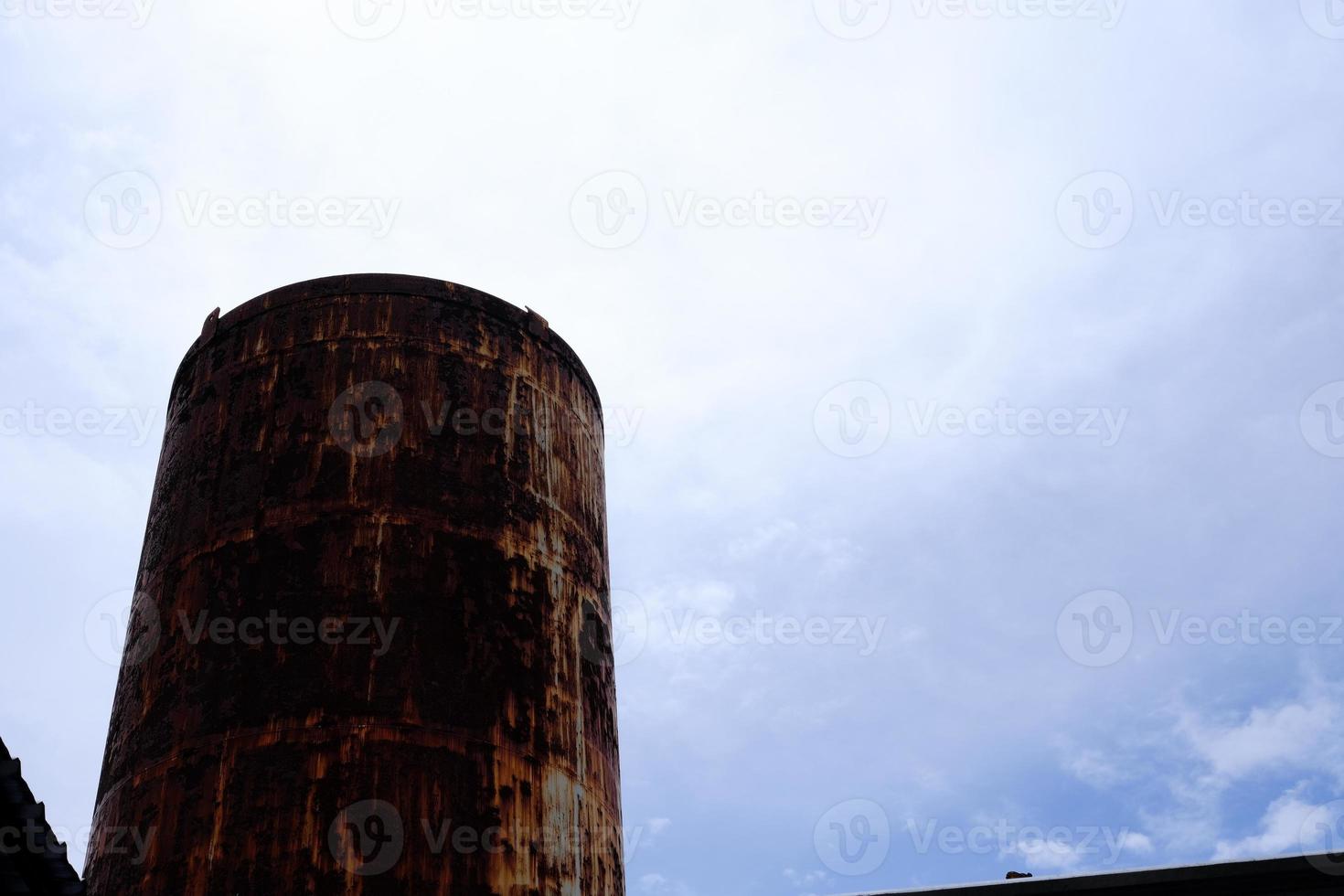 Old Rustic Water Tank with Cloudy Sky Background. photo
