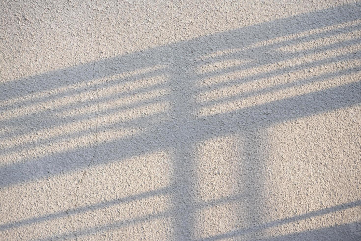 Fence Shadow on Surface of Stucco Wall. photo