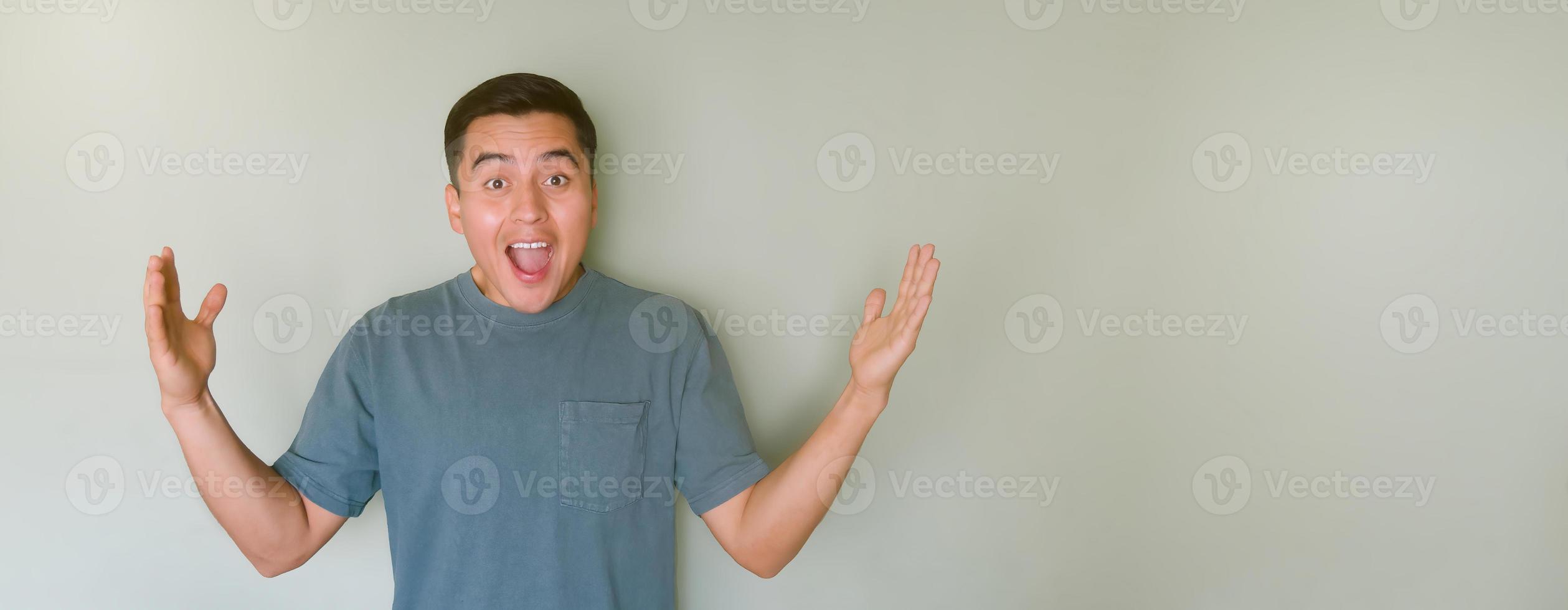 Surprised young man receiving a good news with space for text photo