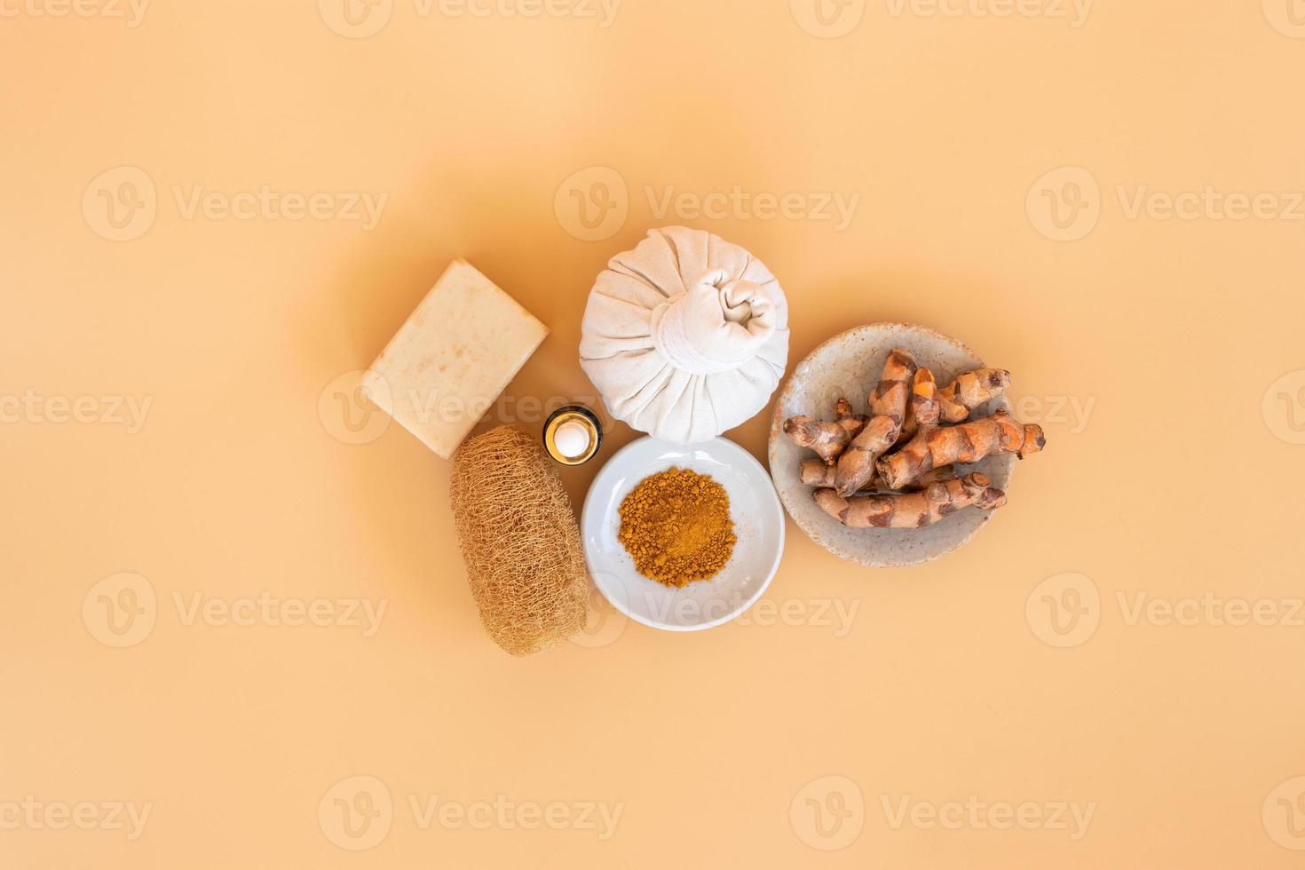 Top view of herbal compress ball with Thai herbal, turmeric, essential oil and bar soap on orange pastel background. Spa background concept. photo