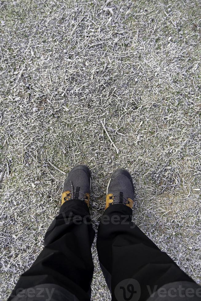 Feet of man on frozen ground photo