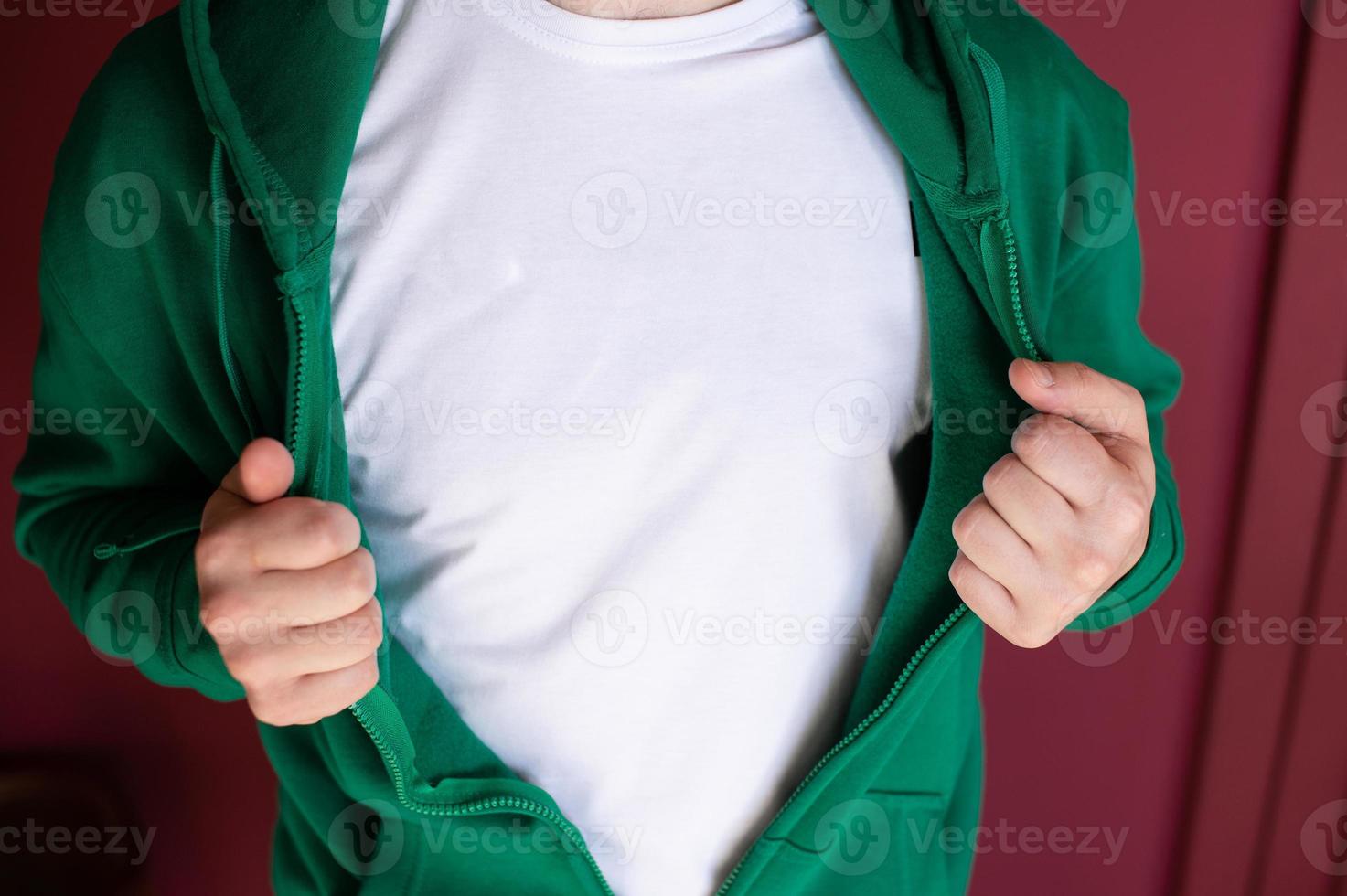 de los hombres manos desabrochado un verde capucha con un blanco camiseta debajo foto