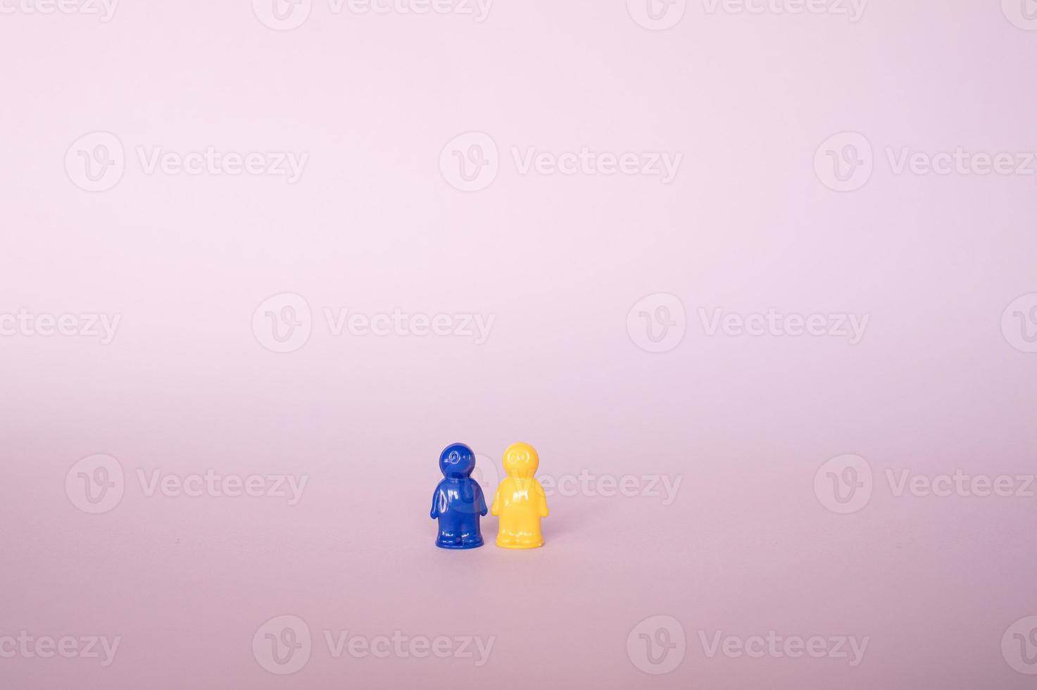 Two figures for a board game in the colors of the Ukrainian flag, standing on a purple background photo