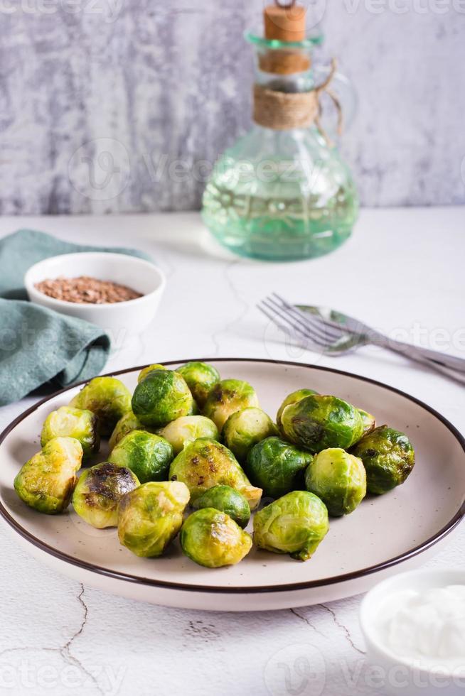 Roasted Brussels sprouts on a plate on the table. Vegetarian diet. Vertcal view photo