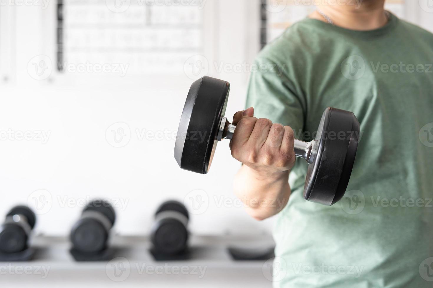 man workout in the indoor gym, man lifting up a Hammer Curl weight exercise. bodybuilding dumbbells in gym. training in fitness gym. photo