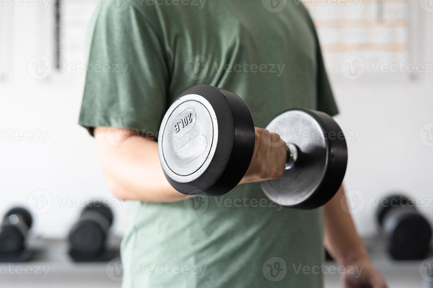 man workout in the indoor gym, man lifting up a Hammer Curl weight exercise. bodybuilding dumbbells in gym. training in fitness gym. photo