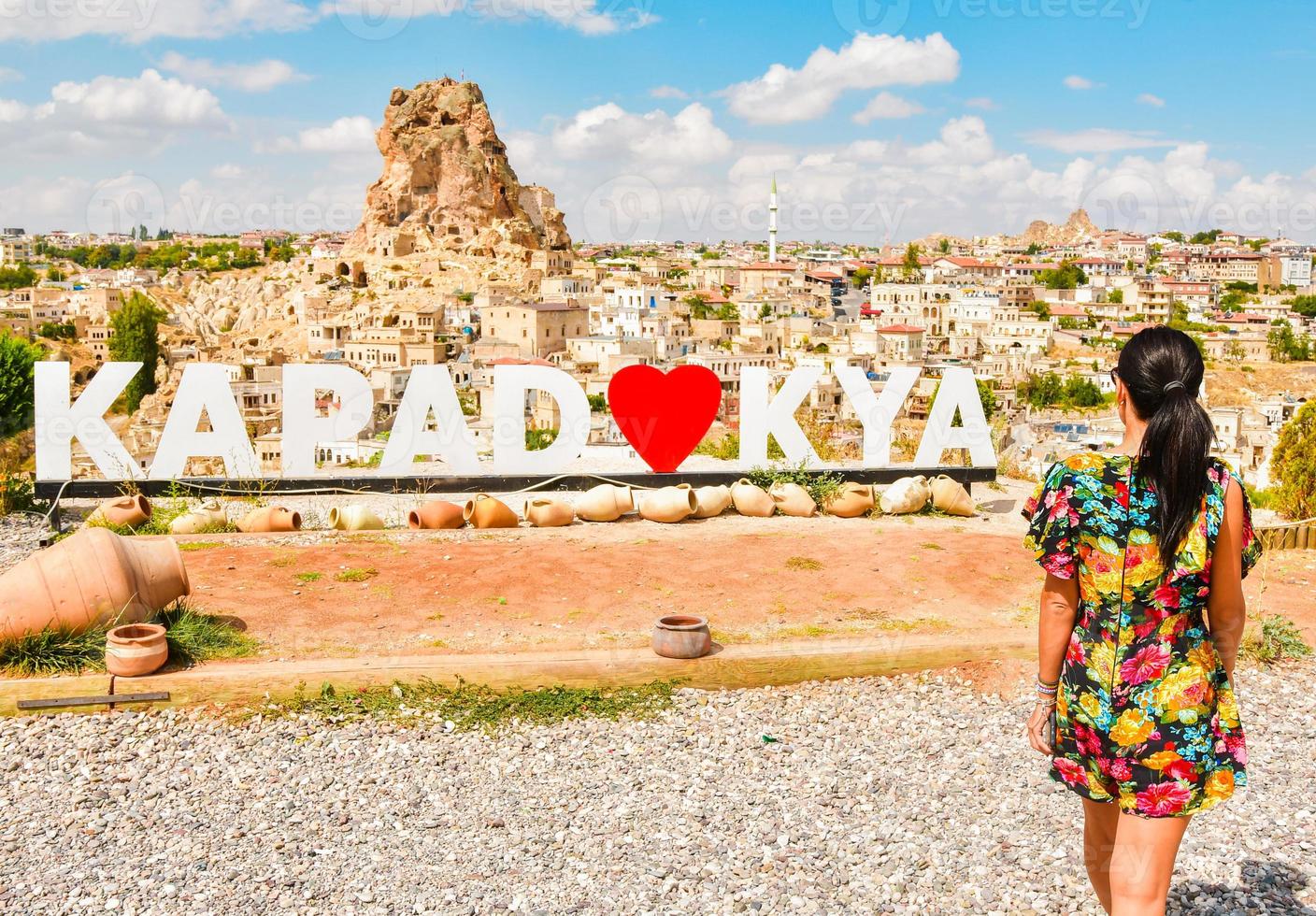 Caucasian female tourist capture with smart phone Ortahisar castle landscape in Cappadocia while summer solo travels in sunny day ,Turkey tourism concept photo