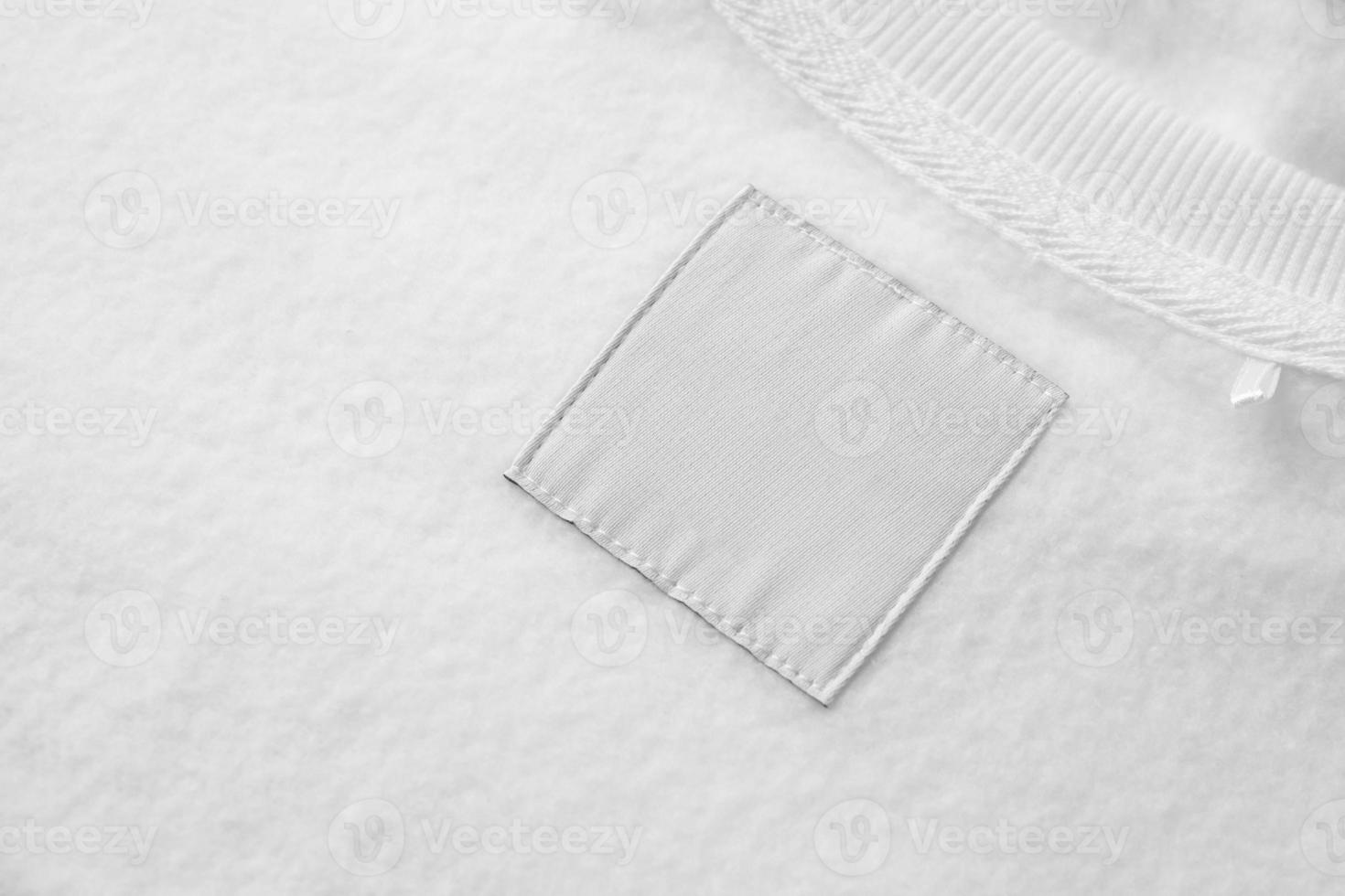 Blank white laundry care clothes label on fabric texture background photo