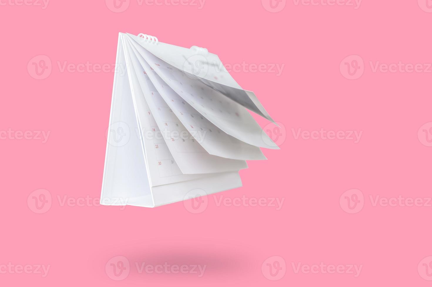 White paper desk calendar flipping page mockup isolated on pink background photo