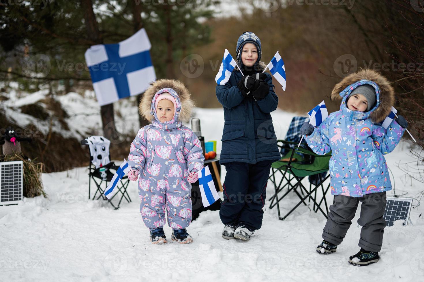 Three finnish children with Finland flags on a nice winter day. Nordic Scandinavian people. photo