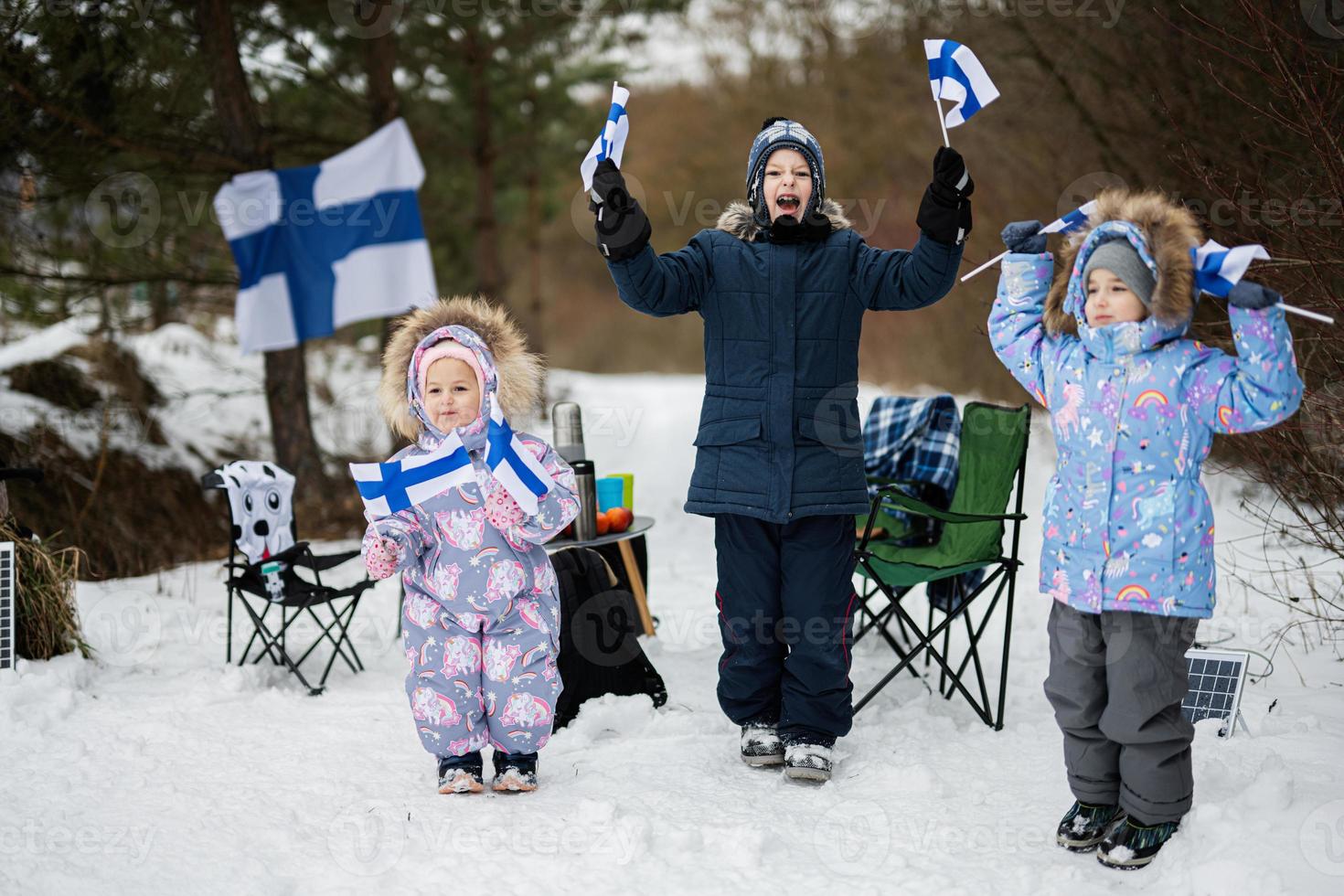 Three finnish children with Finland flags on a nice winter day. Nordic Scandinavian people. photo