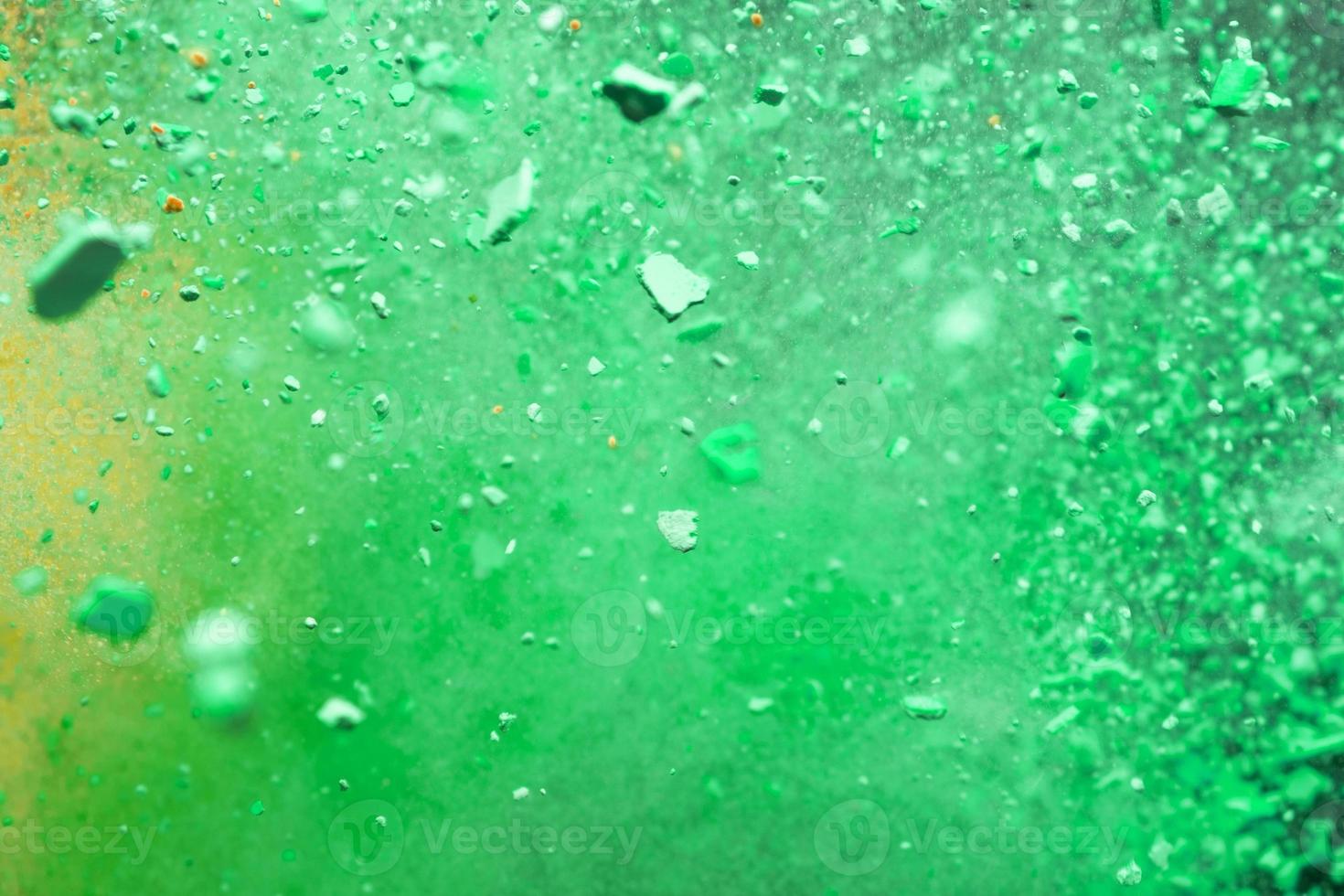 A burst of colorful yellow-green particles. Abstract splash background with selective focus photo