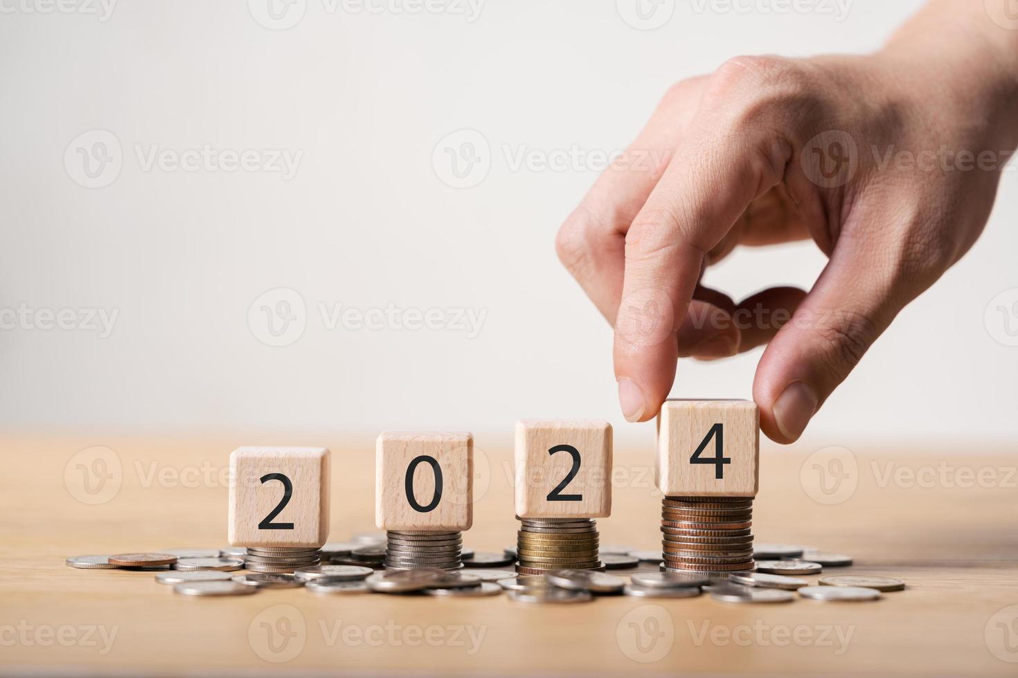 2024 new year goals planning concept, wooden cubes on stack of coins