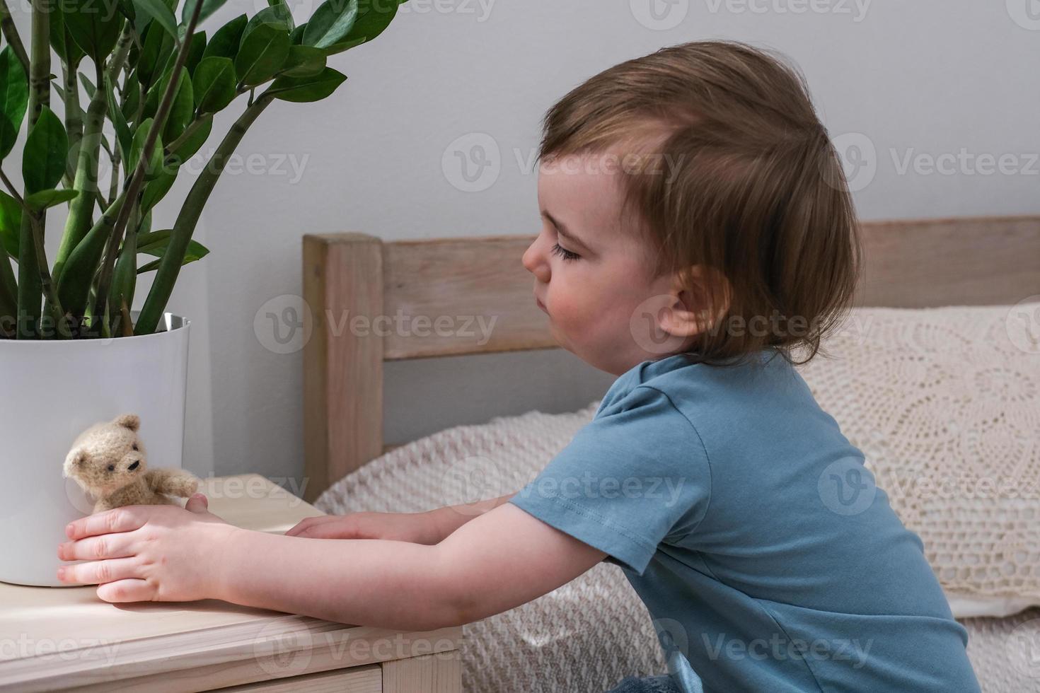 Little boy playing with a teddy bear. Child playing with his favorite toy. photo