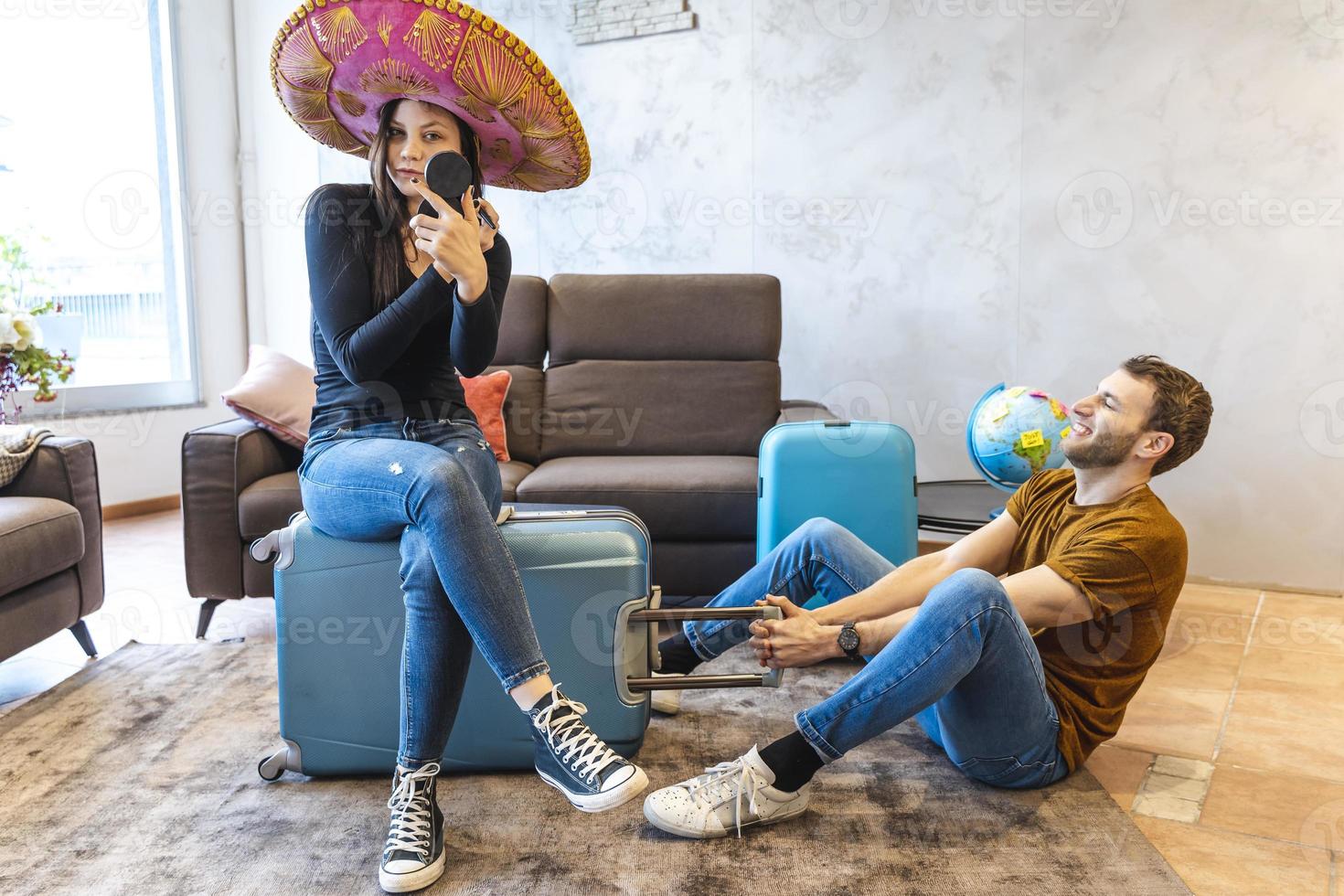young womanwearing sombrero is finishing her make up before leaving photo