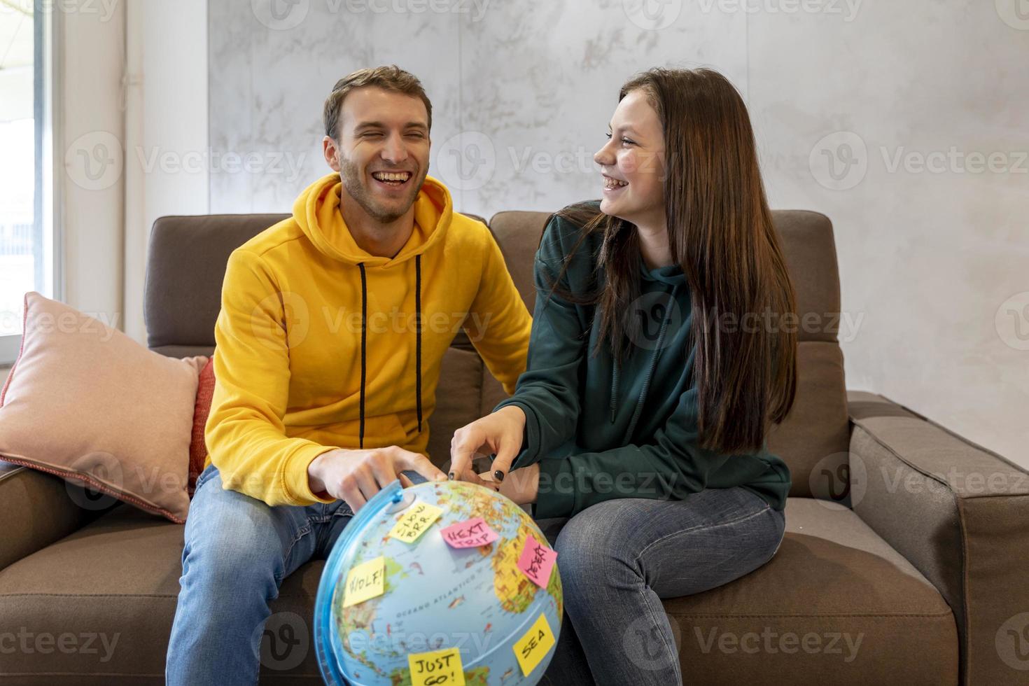 young couple is planning the next trip by choosing the destination photo