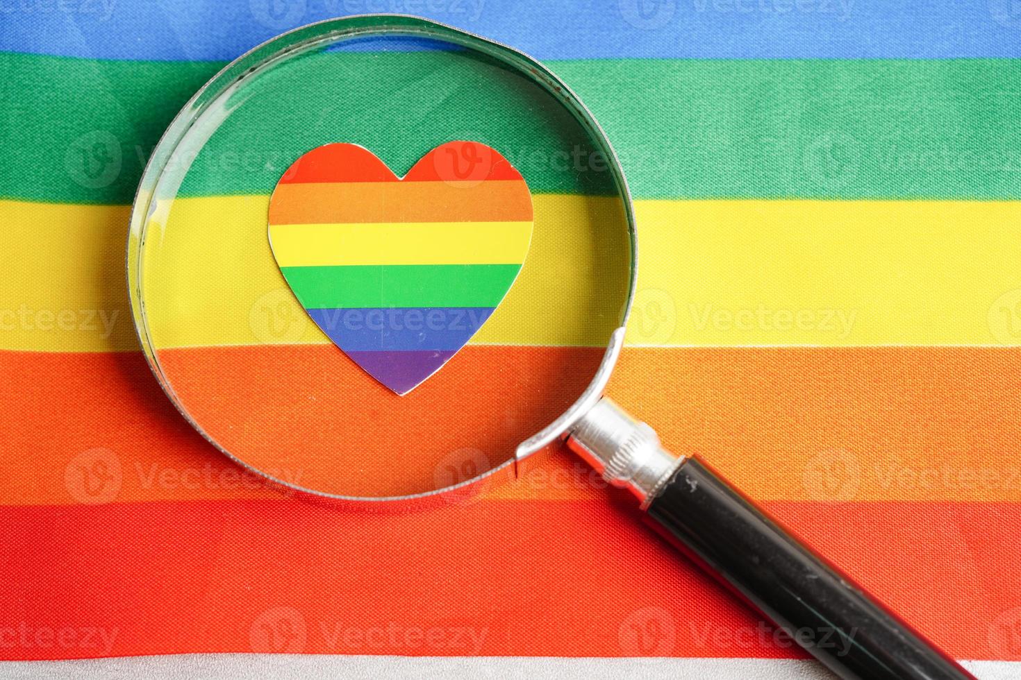 Magnifying glass with heart  on rainbow flag, symbol of LGBT pride month  celebrate annual in June social, symbol of gay, lesbian, bisexual, transgender, human rights and peace. photo