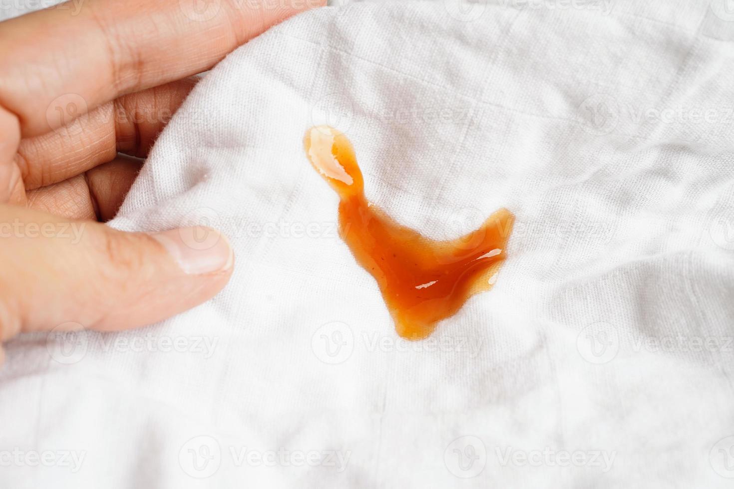 Dirty spicy sauce stain on cloth to wash with washing powder, cleaning housework concept. photo