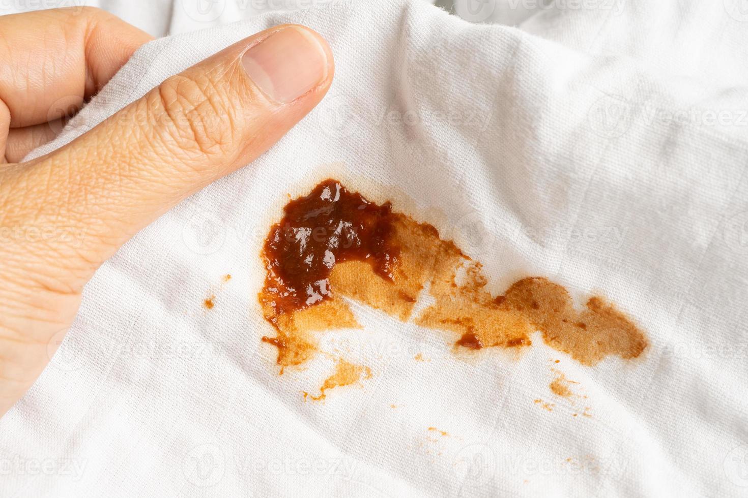 mancha de salsa de tomate sucia o ketchup en tela para lavar con detergente en polvo, limpieza del concepto de tareas domésticas. foto