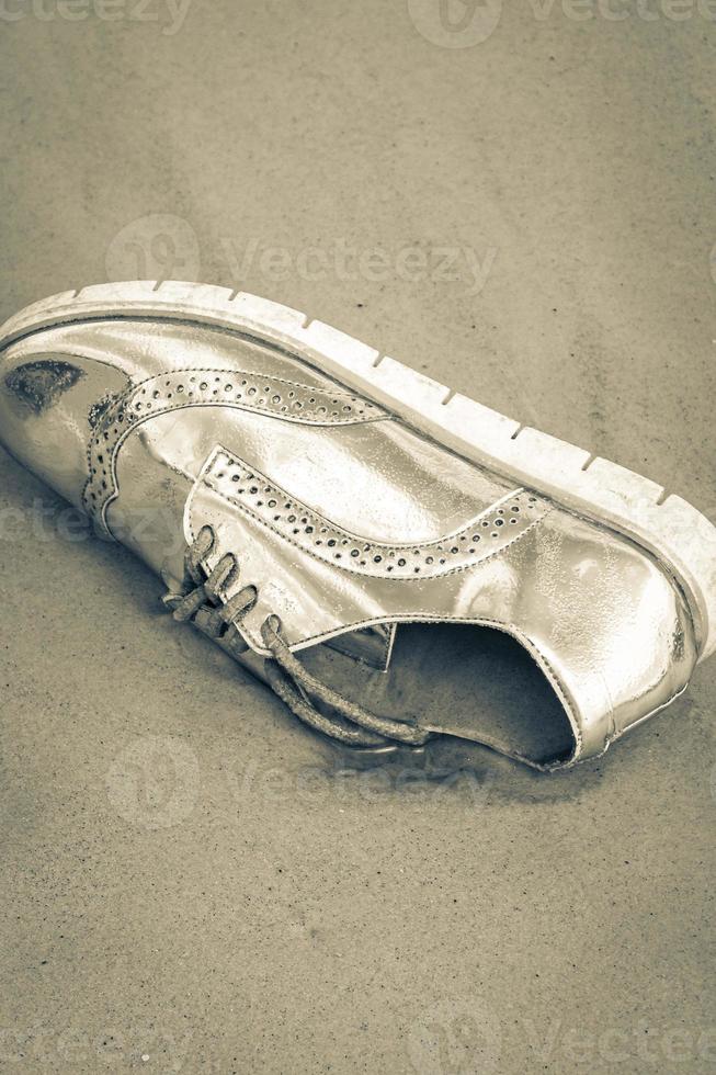 Golden shoe stranded washed up garbage pollution on beach Brazil. photo