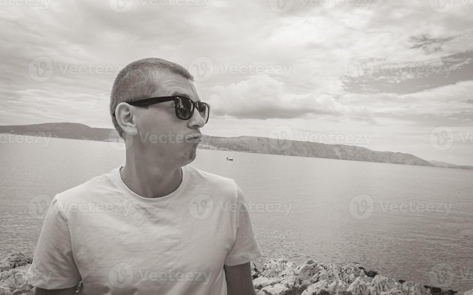 Young male model with sunglasses at Novi Vinodolski Croatia landscape. photo