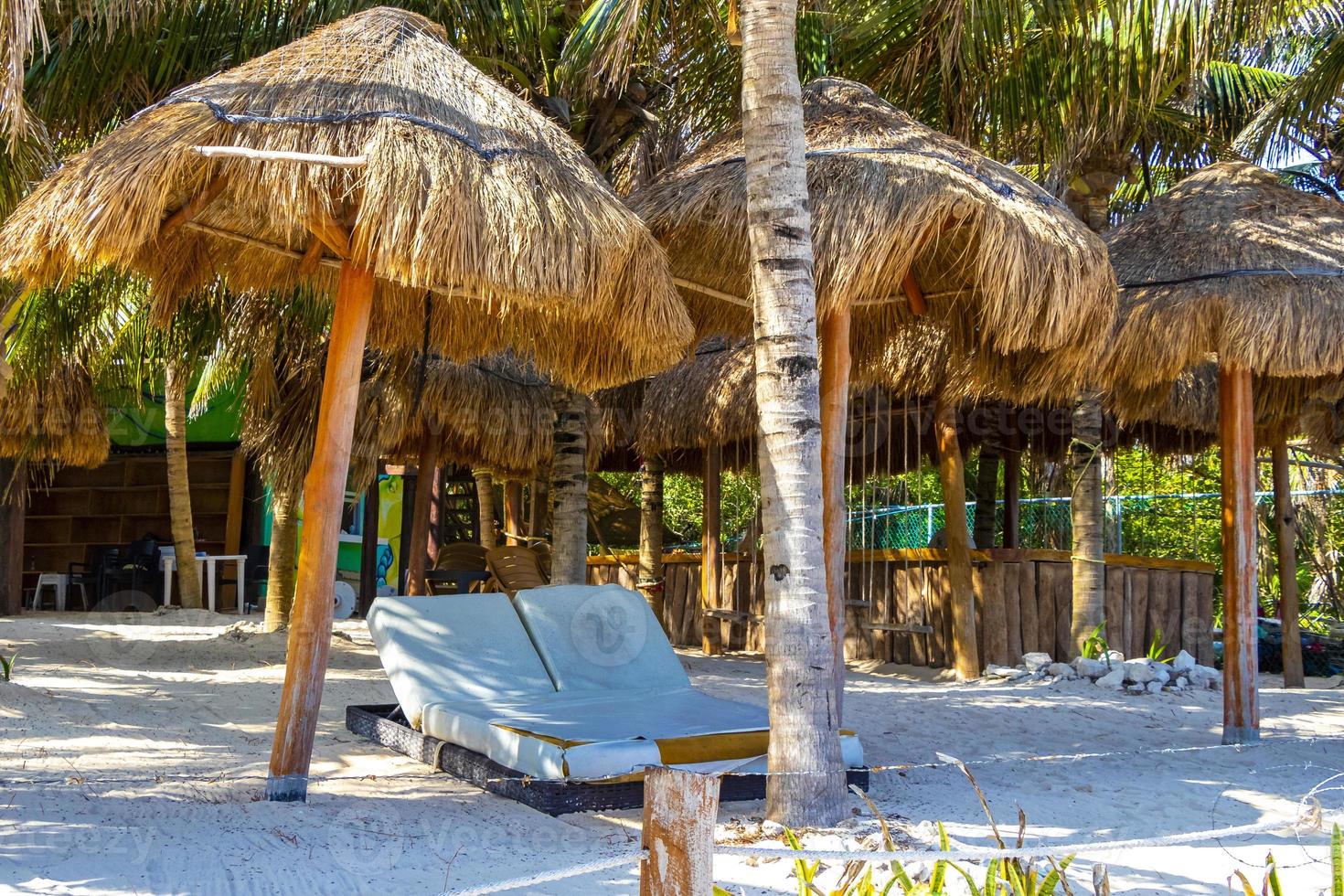 Palms parasols sun loungers beach resort Playa del Carmen Mexico. photo