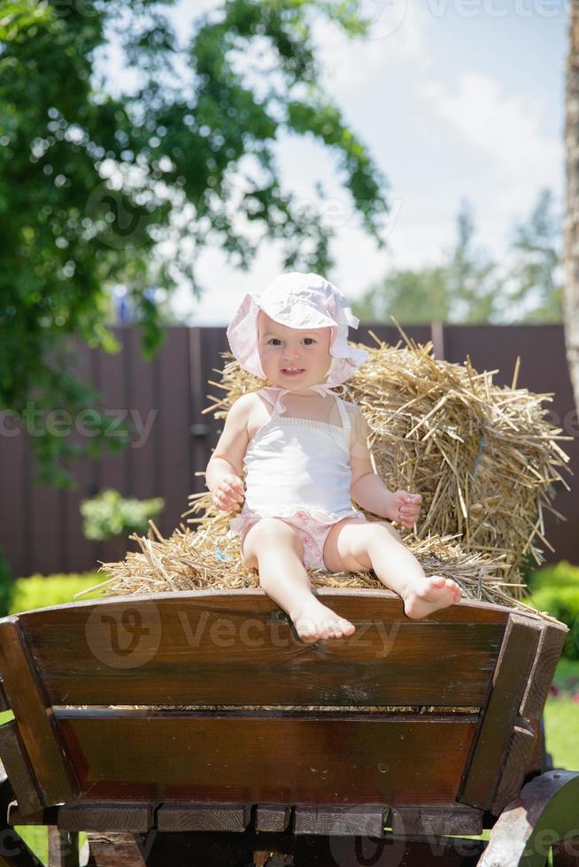 Nice little girl sitting on a carriage photo