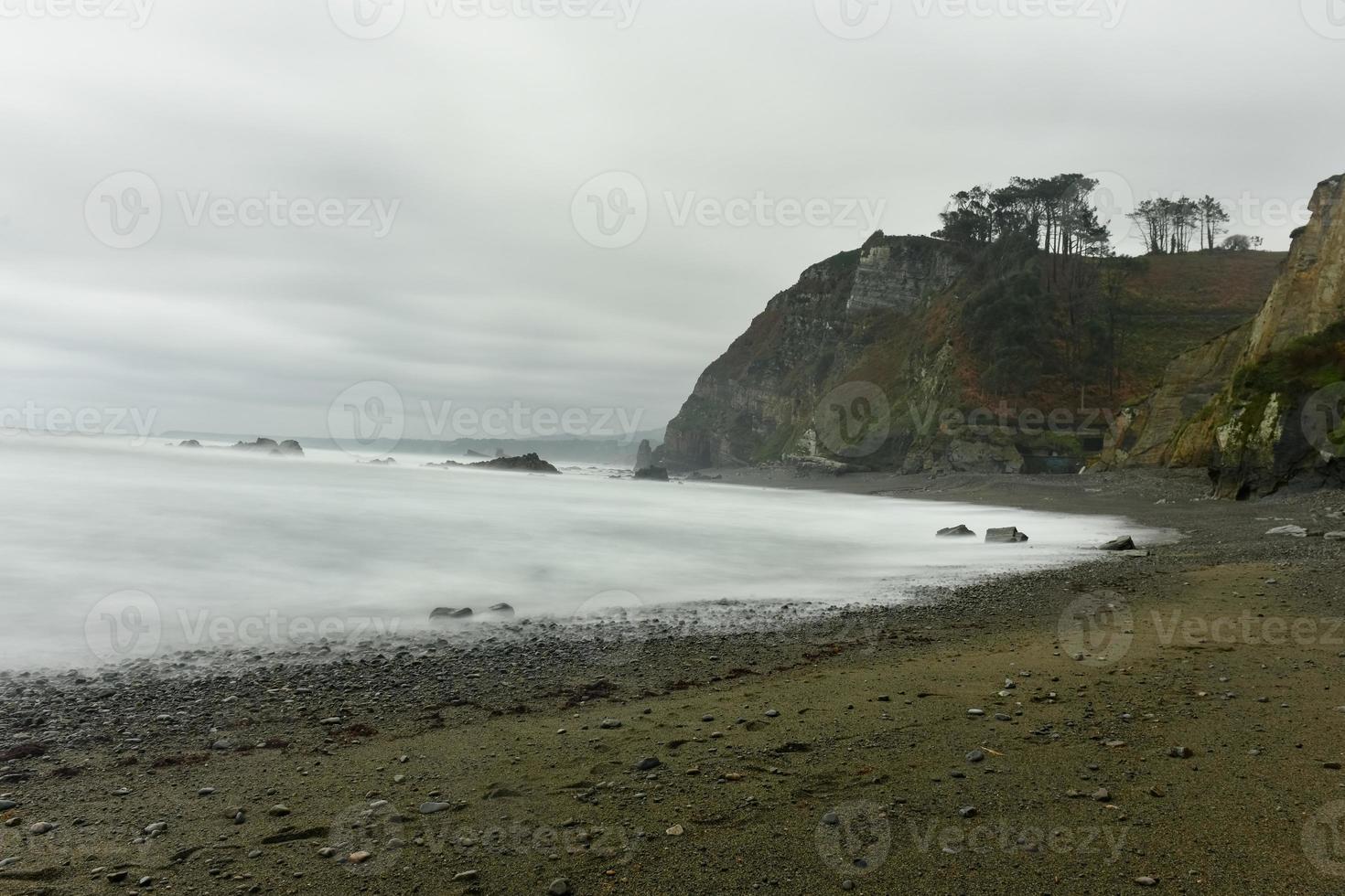 The Campiecho beach is located in Asturias, Spain on a cloudy day. photo