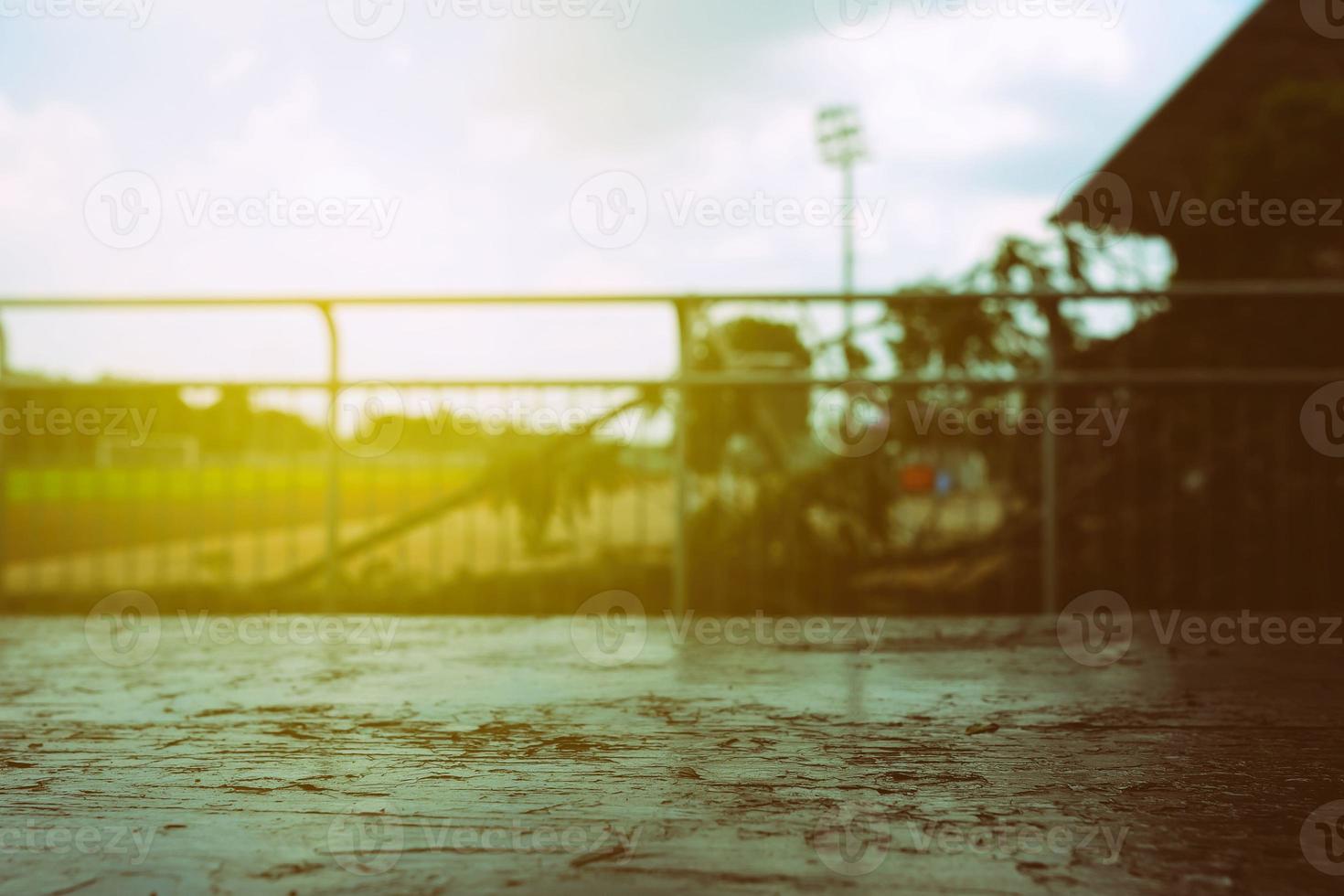 Close up Old Wooden Table with Blurred Soccer Field Background and Light Leak. photo