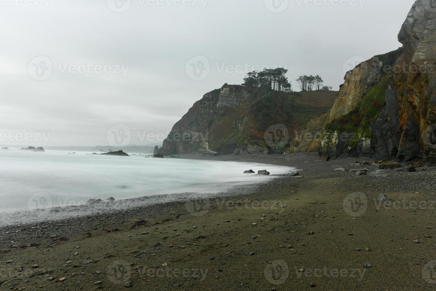 The Campiecho beach is located in Asturias, Spain on a cloudy day. photo