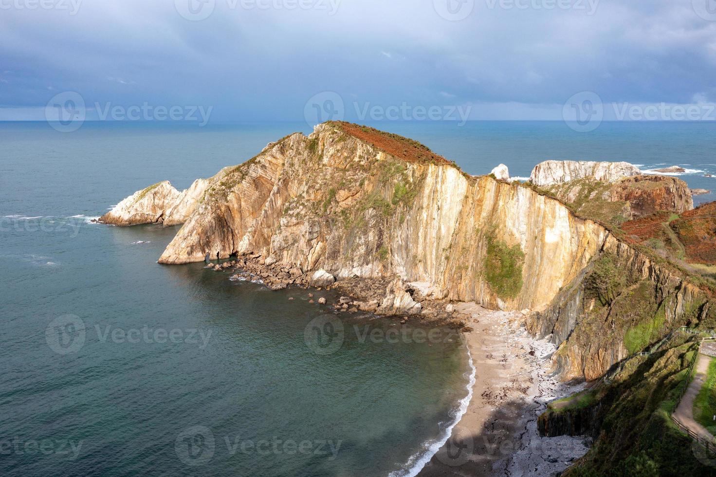 Silence beach, silver-sandy cove backed by a natural rock amphitheatre in Asturias, Spain. photo