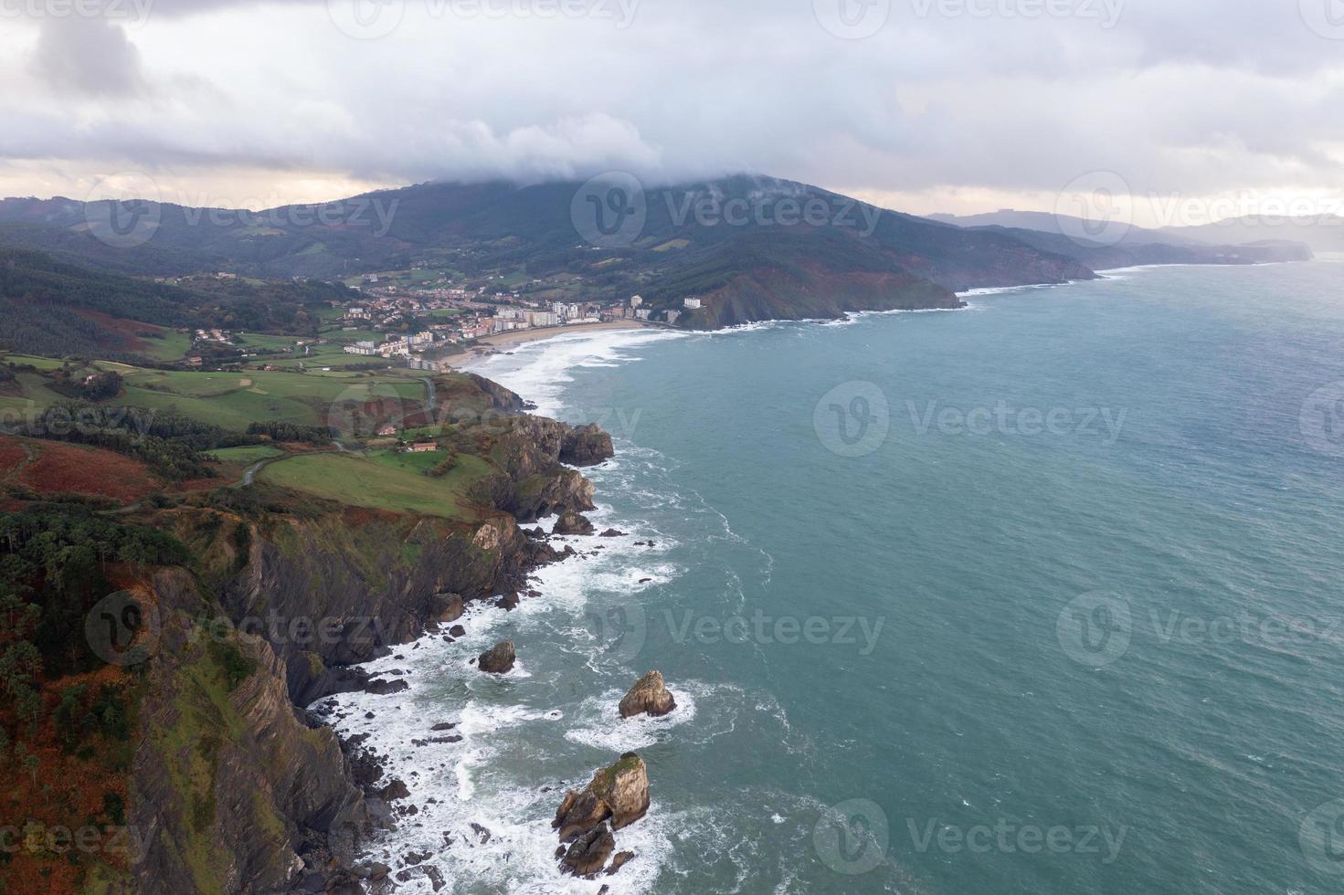 Green rocky mountains and beautiful coastline scenery by Gaztelugatxe, Spain photo