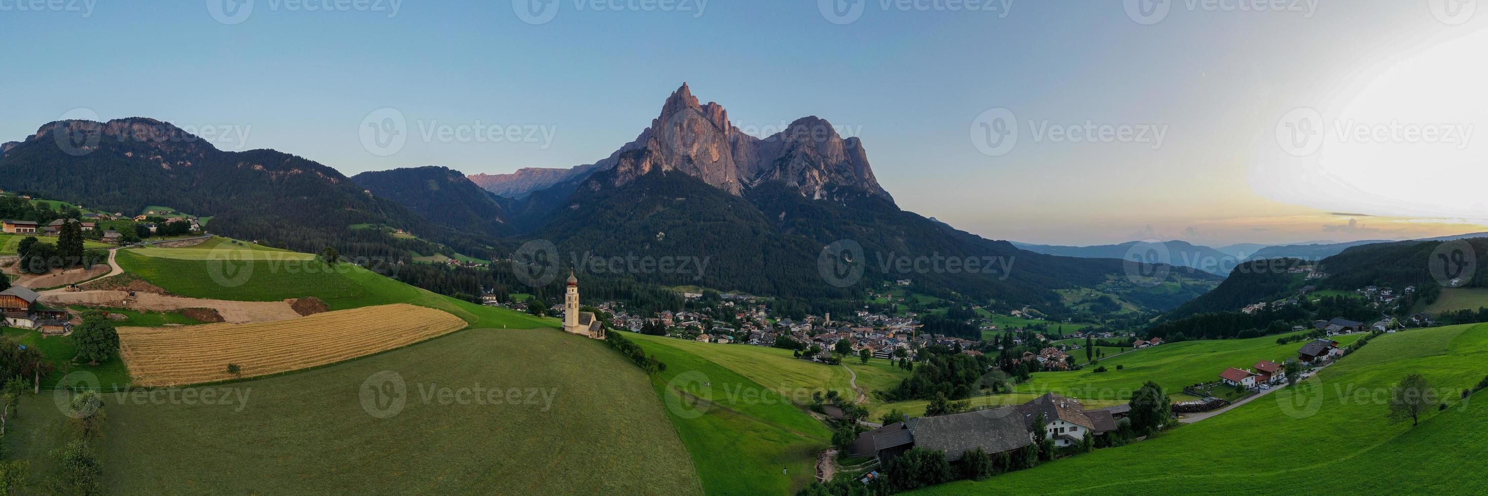 St. Valentin  Kastelruth  Village Church in the summer in the Dolomite Alps. Amazing landscape with small chapel on sunny meadow and Petz peak at Kastelruth commune. Dolomites, South Tyrol, Italy photo