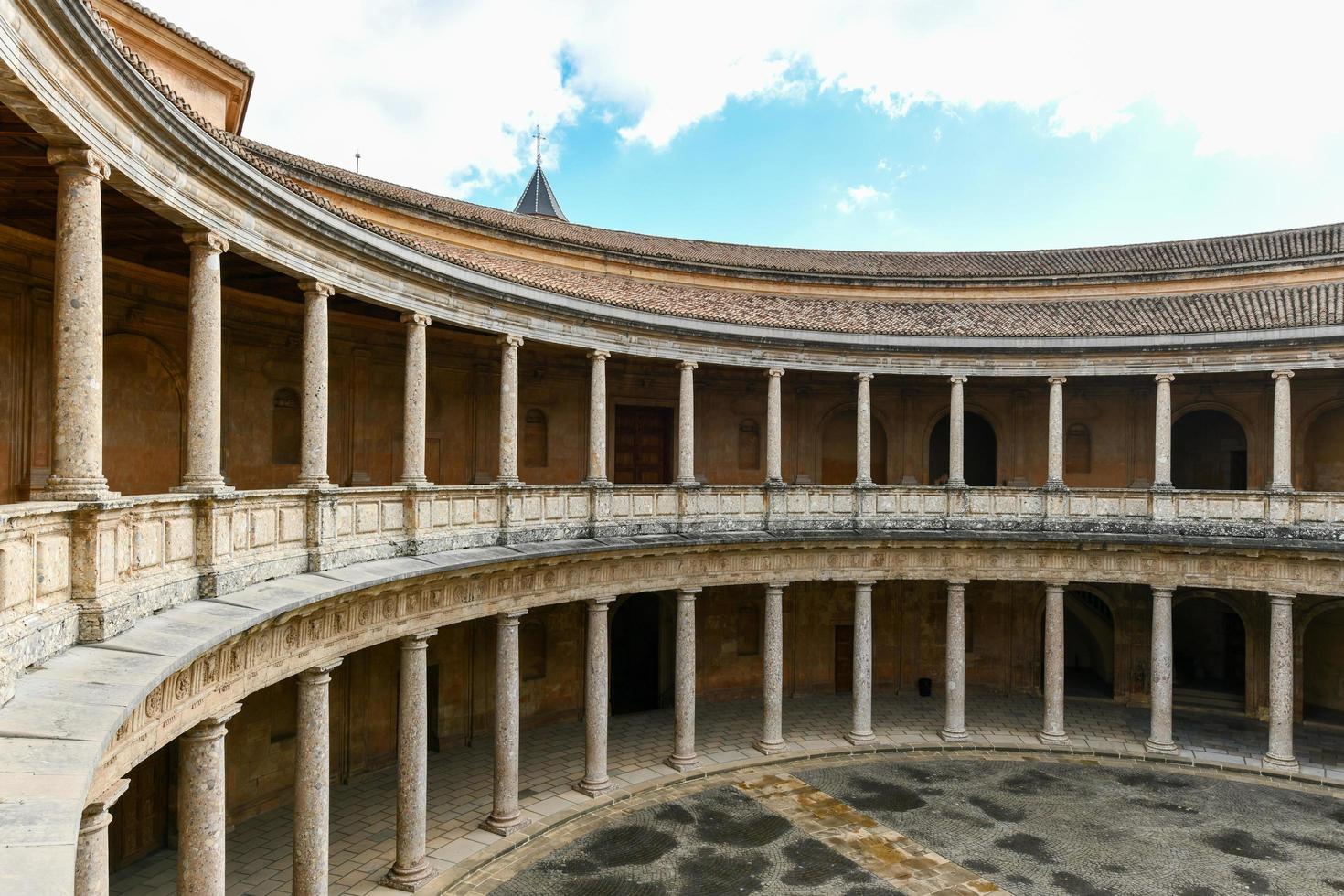 Granada, Spain - Nov 29, 2021, The unique circular patio of the Palace of Charles V  Palacio de Carlos V  with its two levels of columns of Doric and Ionic colonnades, Alhambra, Granada, Spain. photo