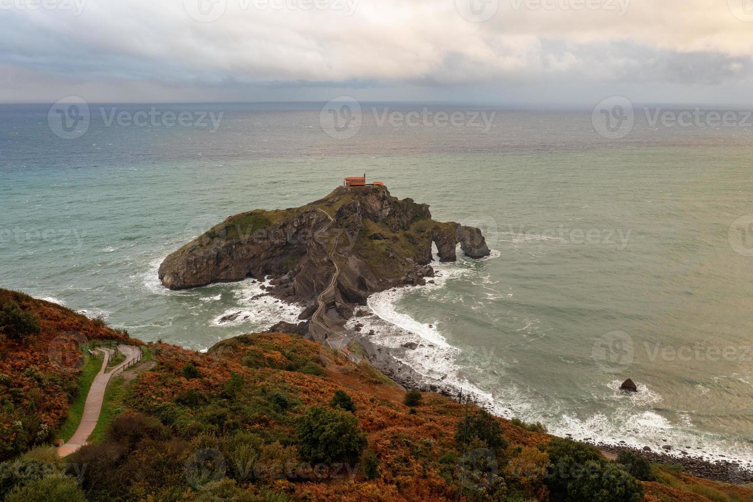 Green rocky mountains and coastline scenery, San Juan de Gaztelugatxe, Spain photo