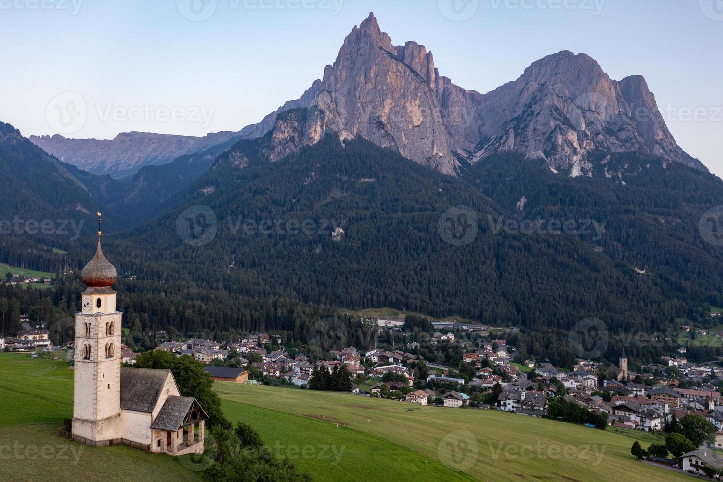 S t. valentin castelruth pueblo Iglesia en el verano en el dolomita Alpes. increíble paisaje con pequeño capilla en soleado prado y mascotas pico a castelruth comuna. dolomitas, sur Tirol, Italia foto