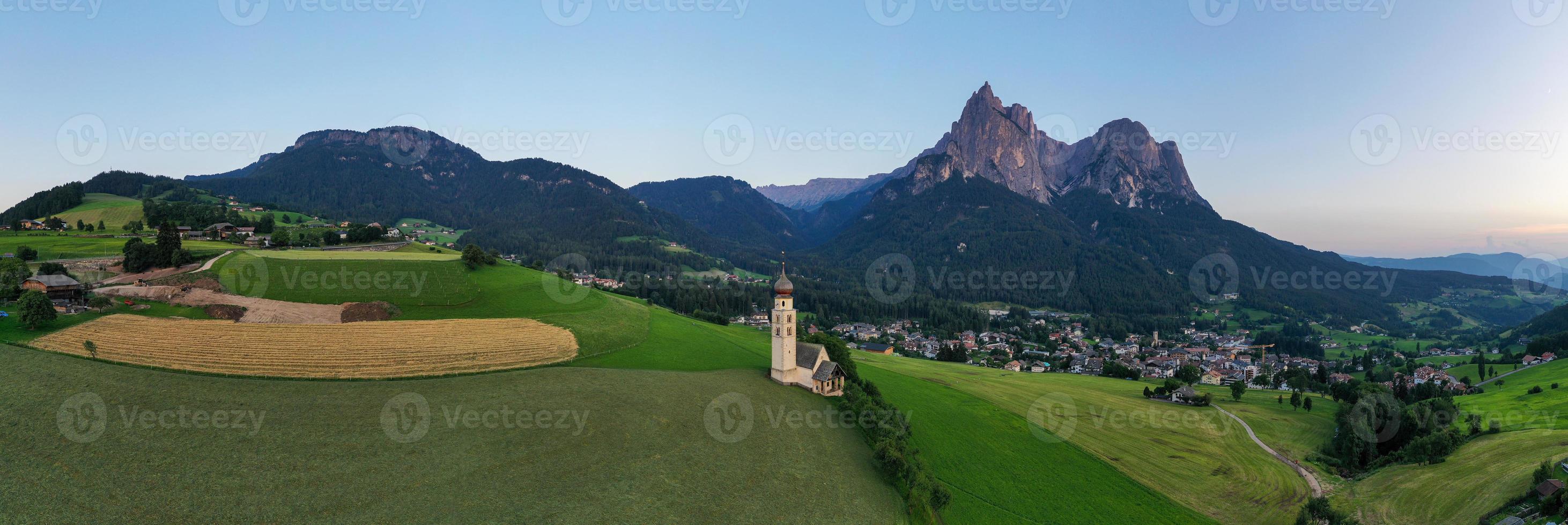 S t. valentin castelruth pueblo Iglesia en el verano en el dolomita Alpes. increíble paisaje con pequeño capilla en soleado prado y mascotas pico a castelruth comuna. dolomitas, sur Tirol, Italia foto