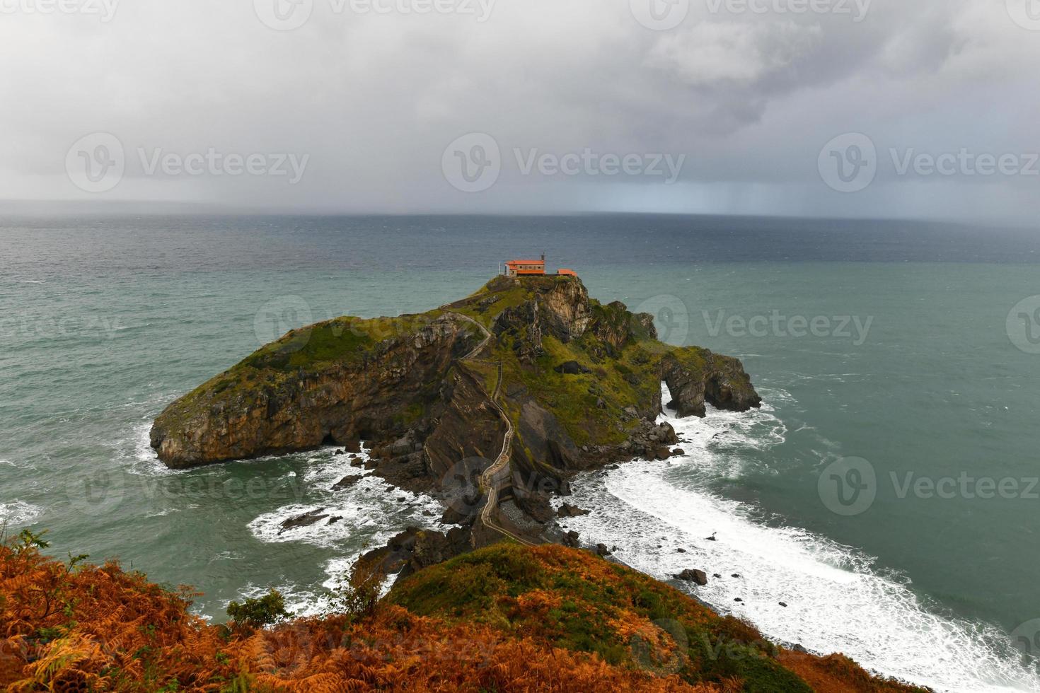 Green rocky mountains and coastline scenery, San Juan de Gaztelugatxe, Spain photo