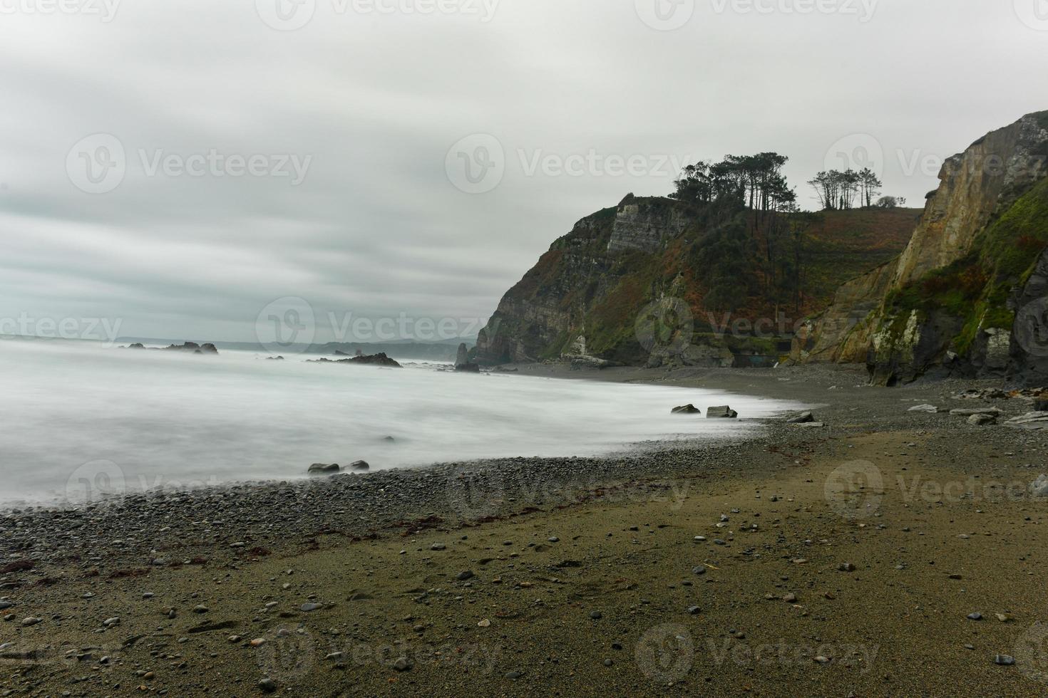 The Campiecho beach is located in Asturias, Spain on a cloudy day. photo