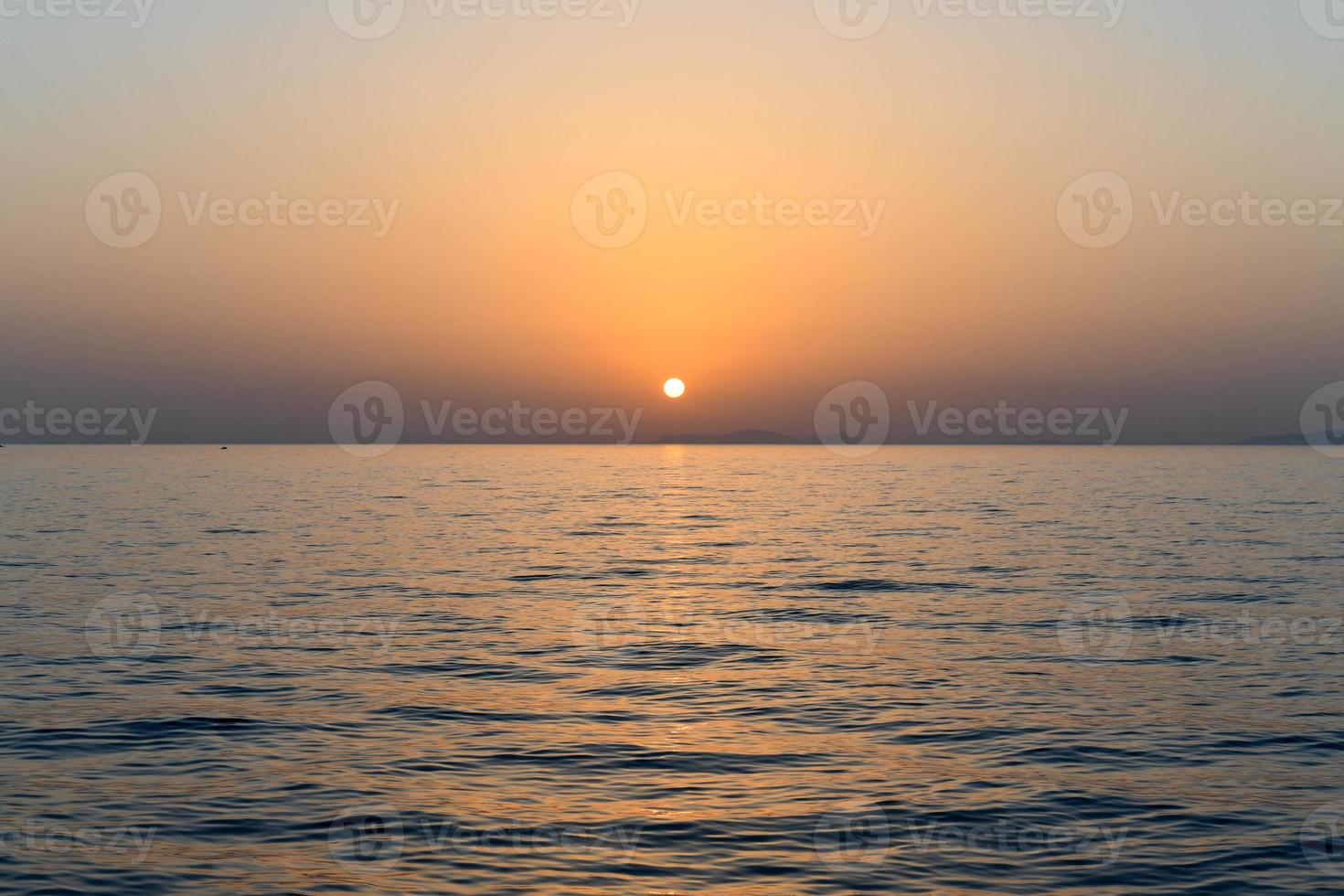 Sunset off of the coast of Oia in the caldera of Santorini, Cyclades islands, Greece, Europe photo