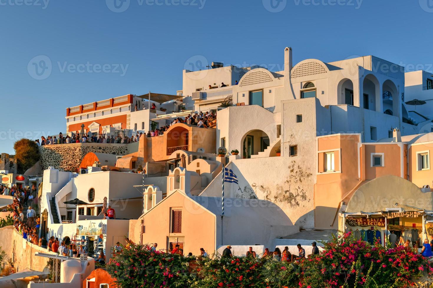 Oia, Greece - Jul 22, 2021, Classic Oia, Santorini skyline at sunset with buildings in Greece. photo