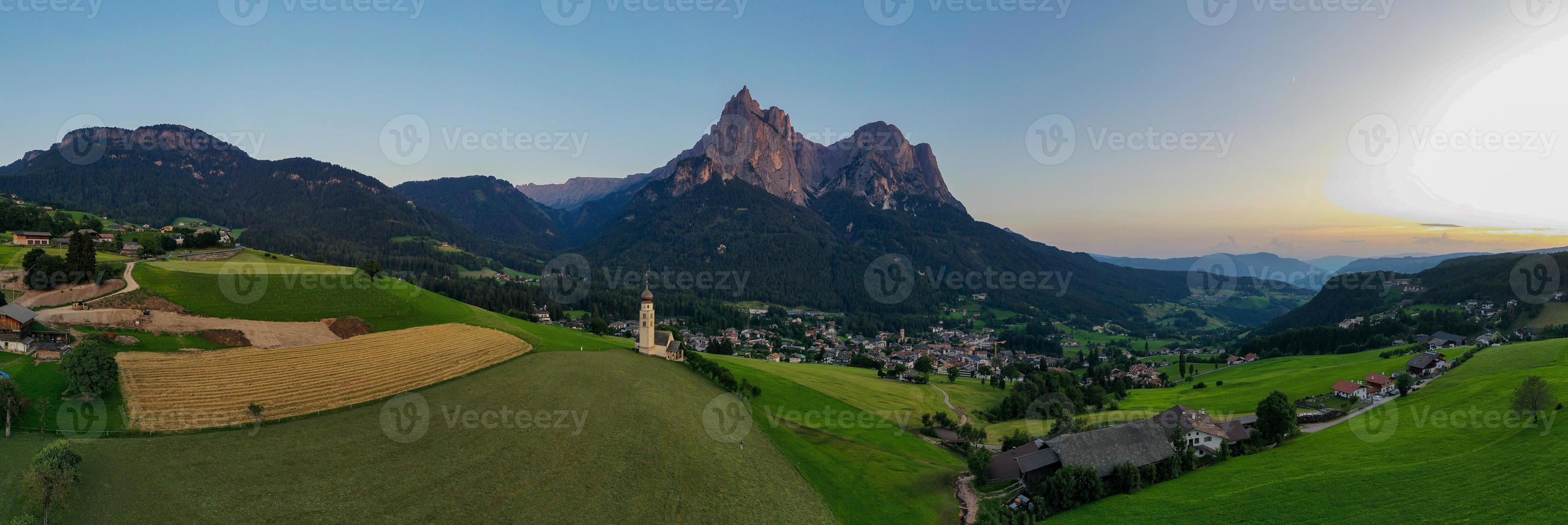 S t. valentin castelruth pueblo Iglesia en el verano en el dolomita Alpes. increíble paisaje con pequeño capilla en soleado prado y mascotas pico a castelruth comuna. dolomitas, sur Tirol, Italia foto