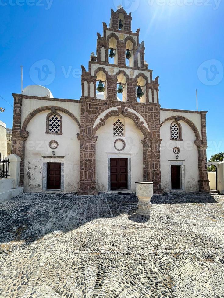 Orthodox Church with its multitiered bell tower facade in Emporio, Santorini, Greece. photo