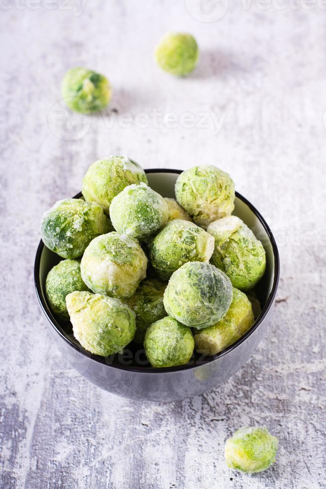 A bowl of frozen brussels sprouts on the table. Vegetable diet. Web banner. Vertical view photo