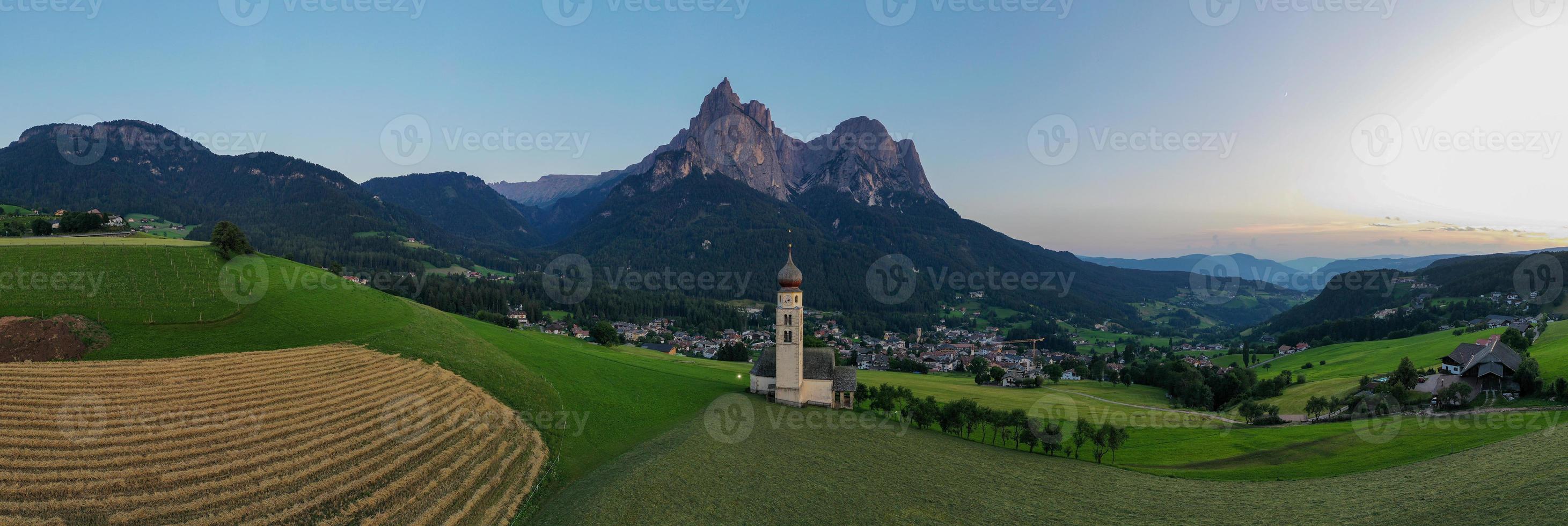 St. Valentin  Kastelruth  Village Church in the summer in the Dolomite Alps. Amazing landscape with small chapel on sunny meadow and Petz peak at Kastelruth commune. Dolomites, South Tyrol, Italy photo