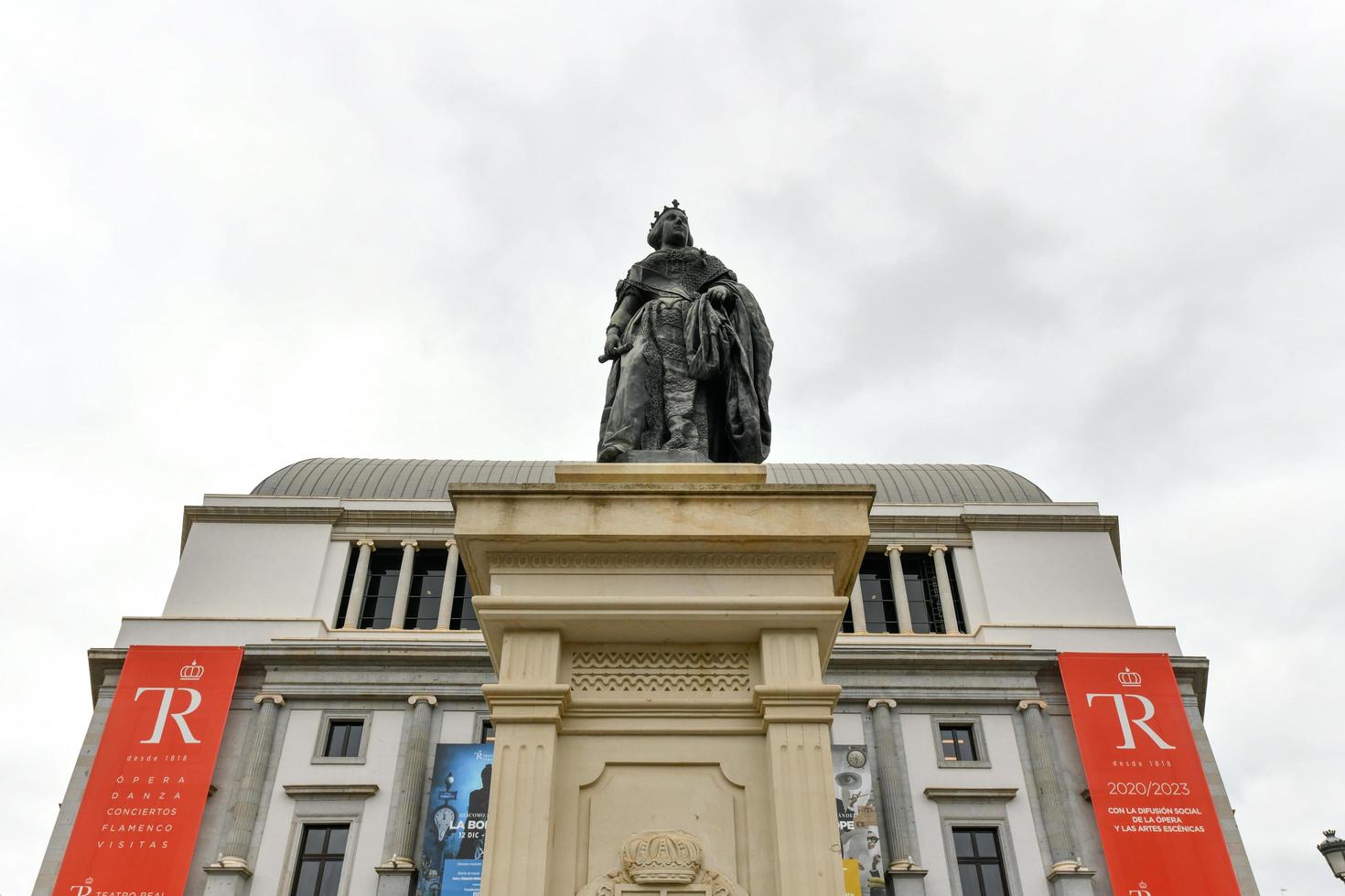 Madrid, Spain - Nov 18, 2021, Monument of the Queen Isabel II of Spain in front of the Teatro Real  Royal Theatre or Madrid Opera  at Plaza de Isabel II  Plaza de la Opera . photo