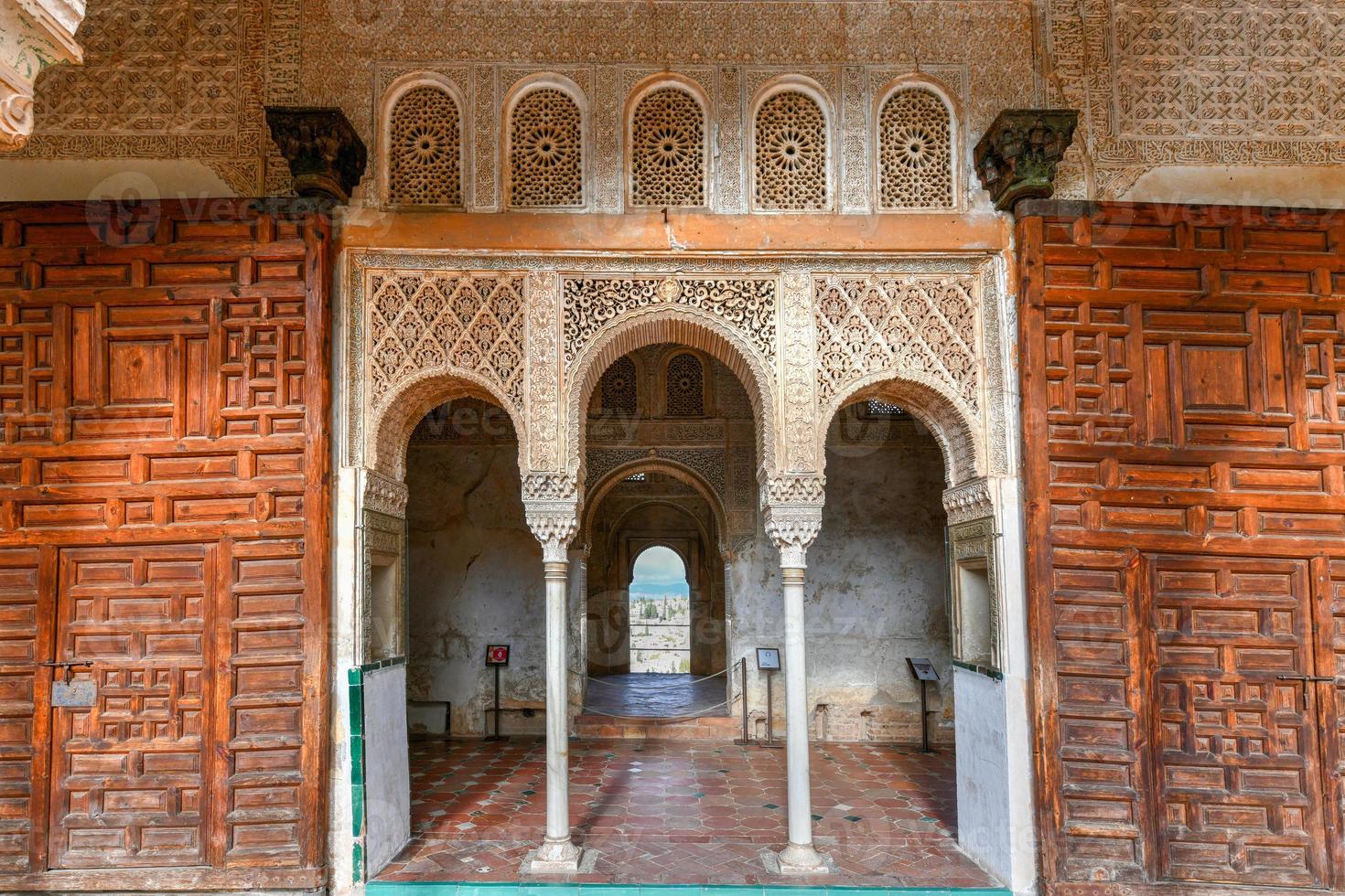 View of The Generalife courtyard, with its famous fountain and garden through an arch. Alhambra de Granada complex at Granada, Spain, Europe on a bright winter day. photo