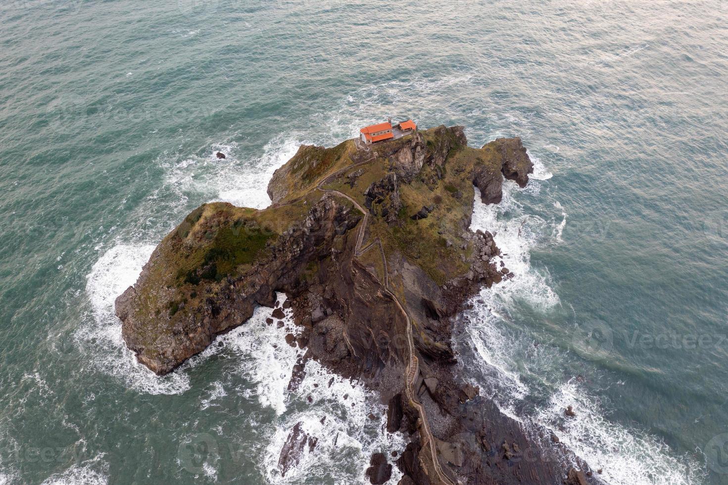 Green rocky mountains and coastline scenery, San Juan de Gaztelugatxe, Spain photo