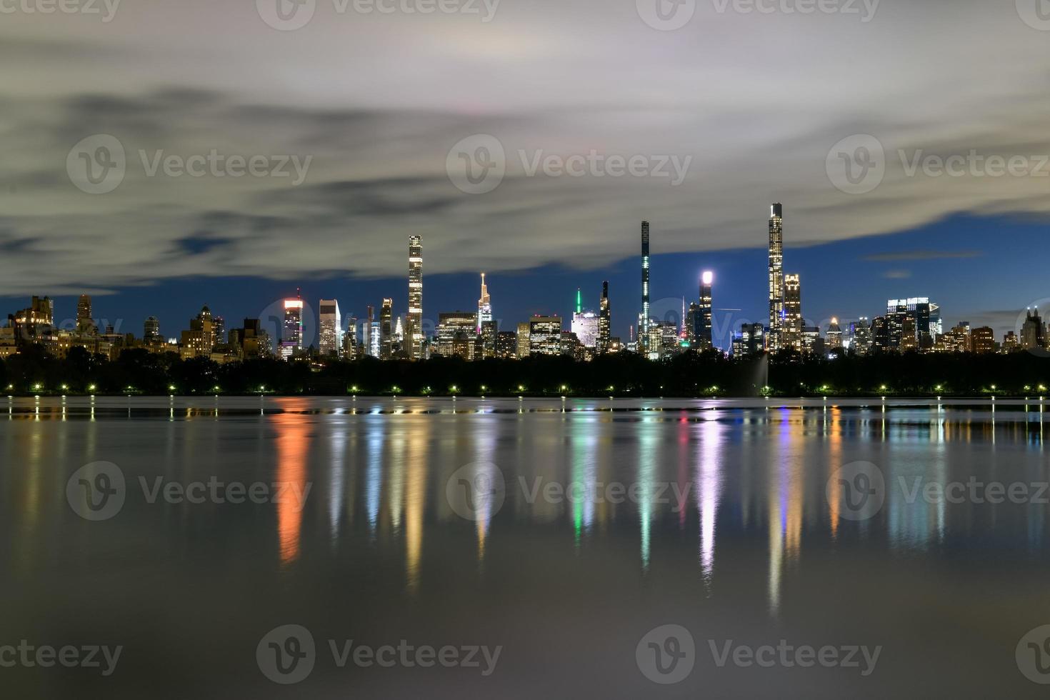 Manhattan horizonte ver a noche desde central parque a través de el central parque reservorio. foto